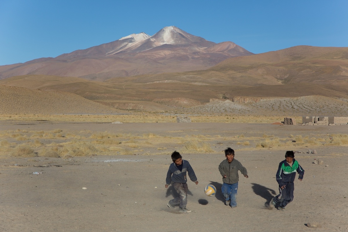 game of football with the background of the twin volcanoes