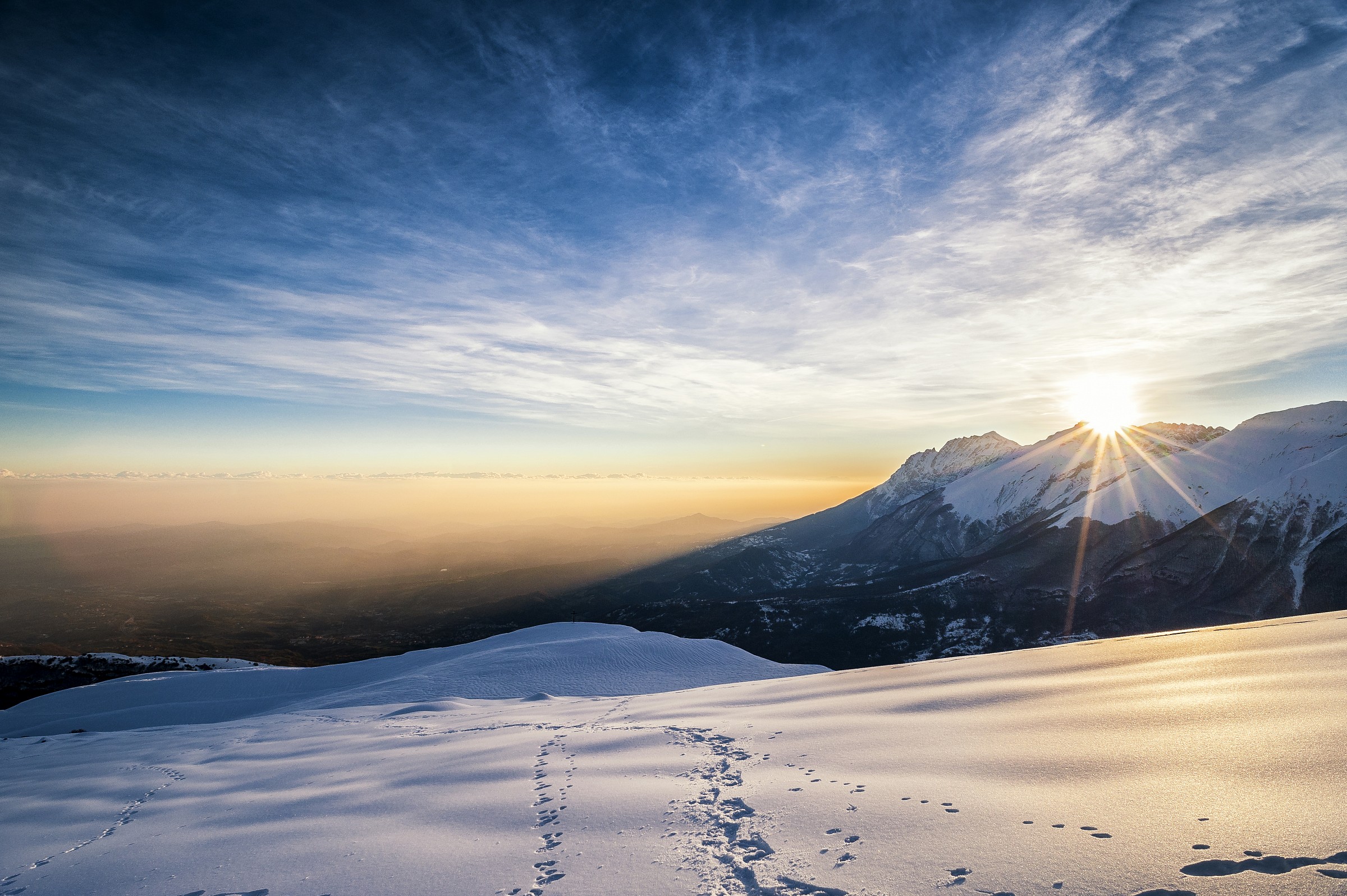 The sun peeps through the tops of the central Apennines