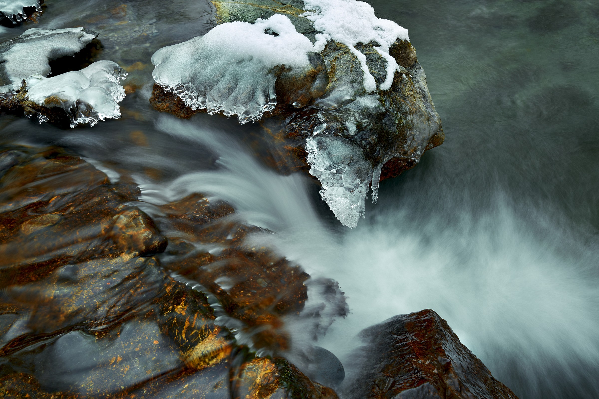 water runs through ice and rocks