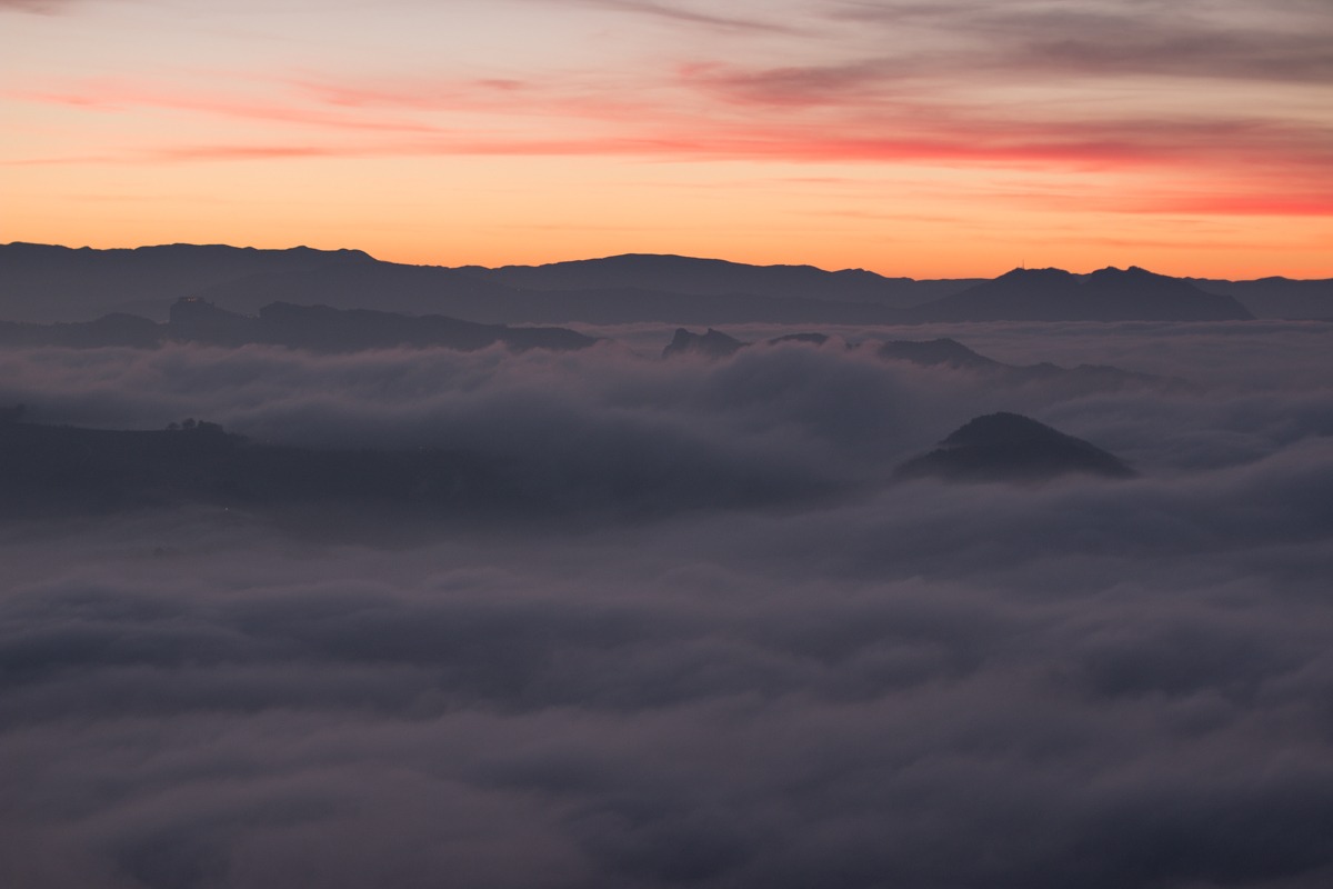 Tramonto con nebbia giù nella valle