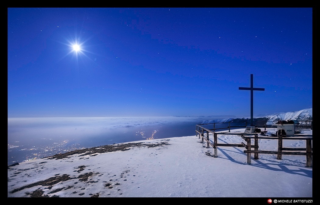 the moon lights the Monte Pizzoc in the starry night.