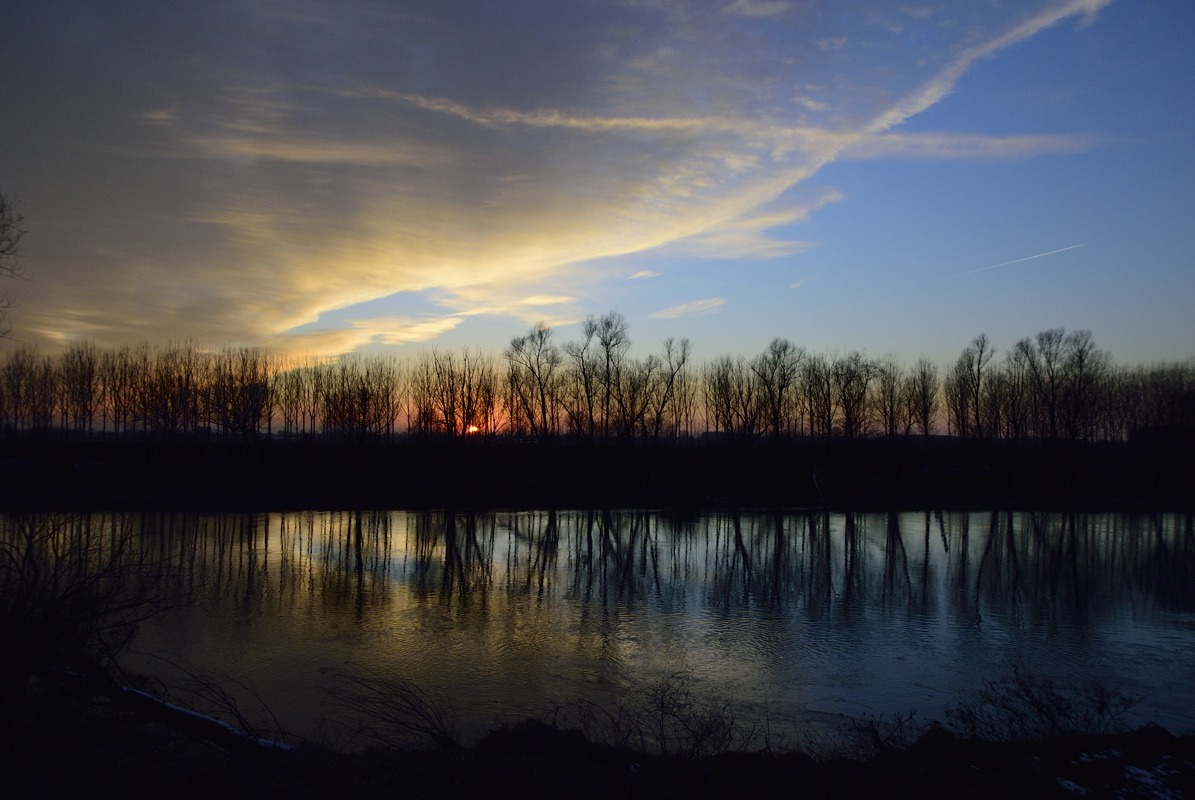 Sunset and reflections on the river Oil