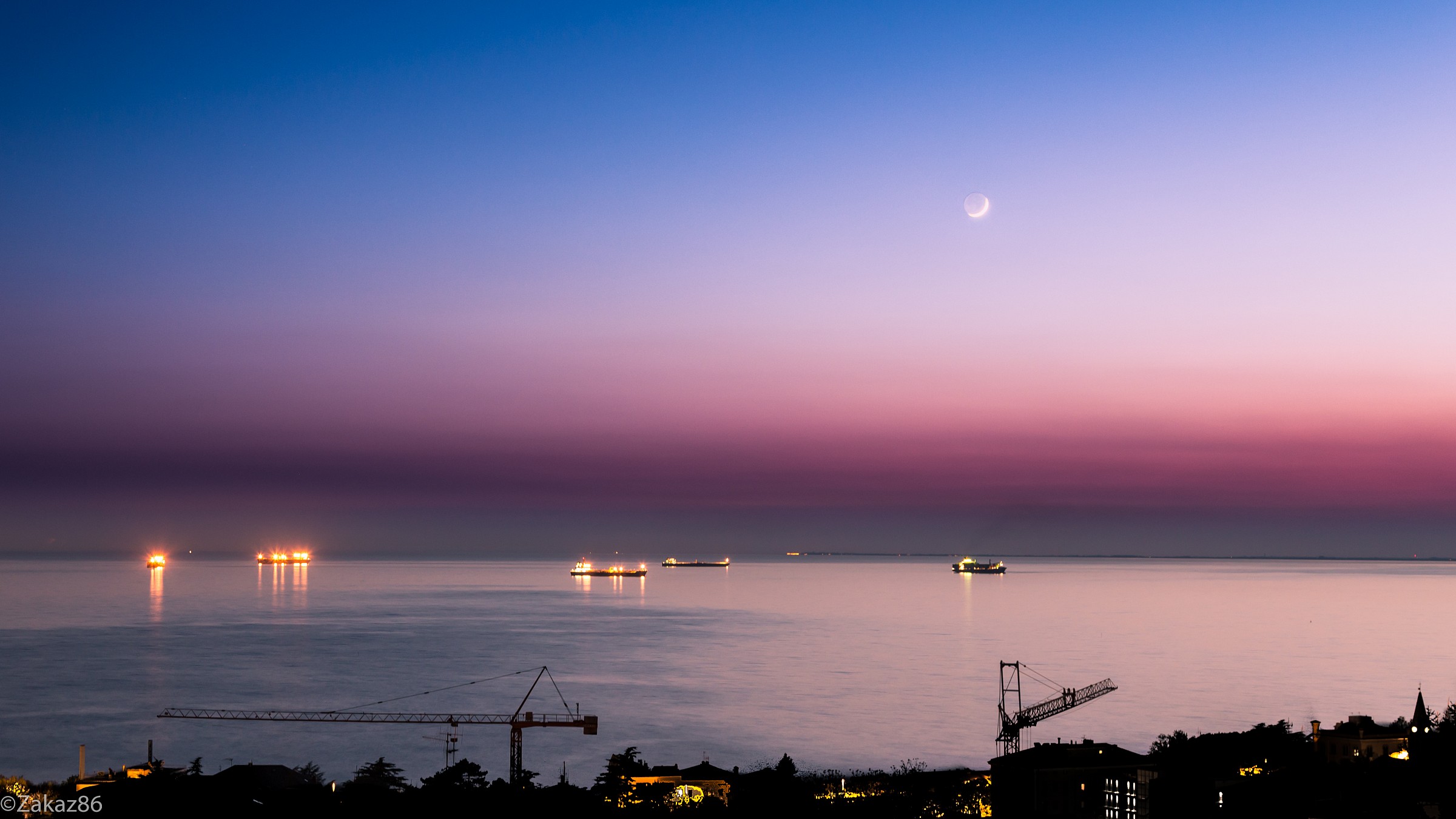 young moon over the boats
