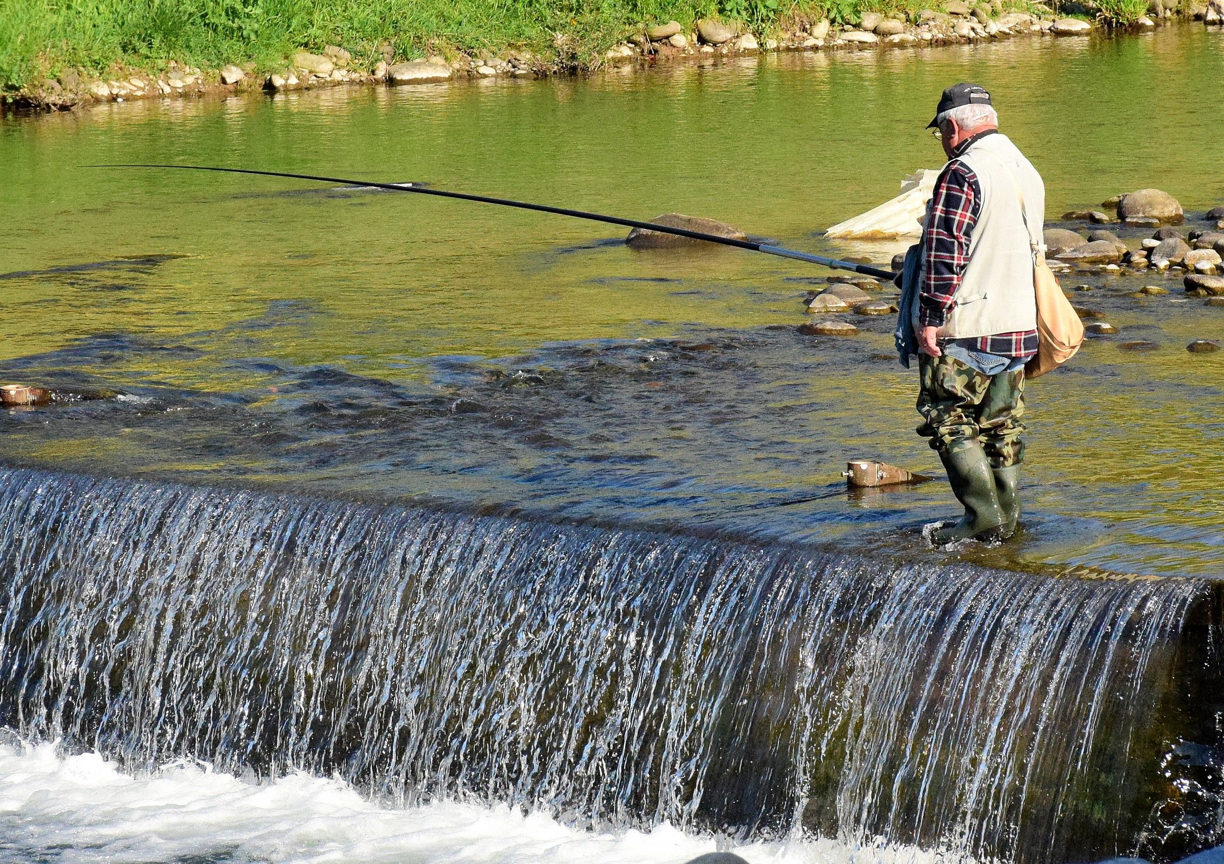 River, waterfall and fisherman