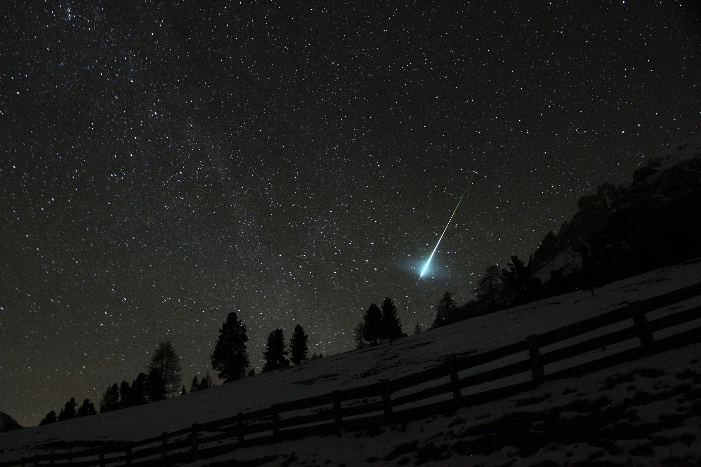 A meteor lights up the night sky.