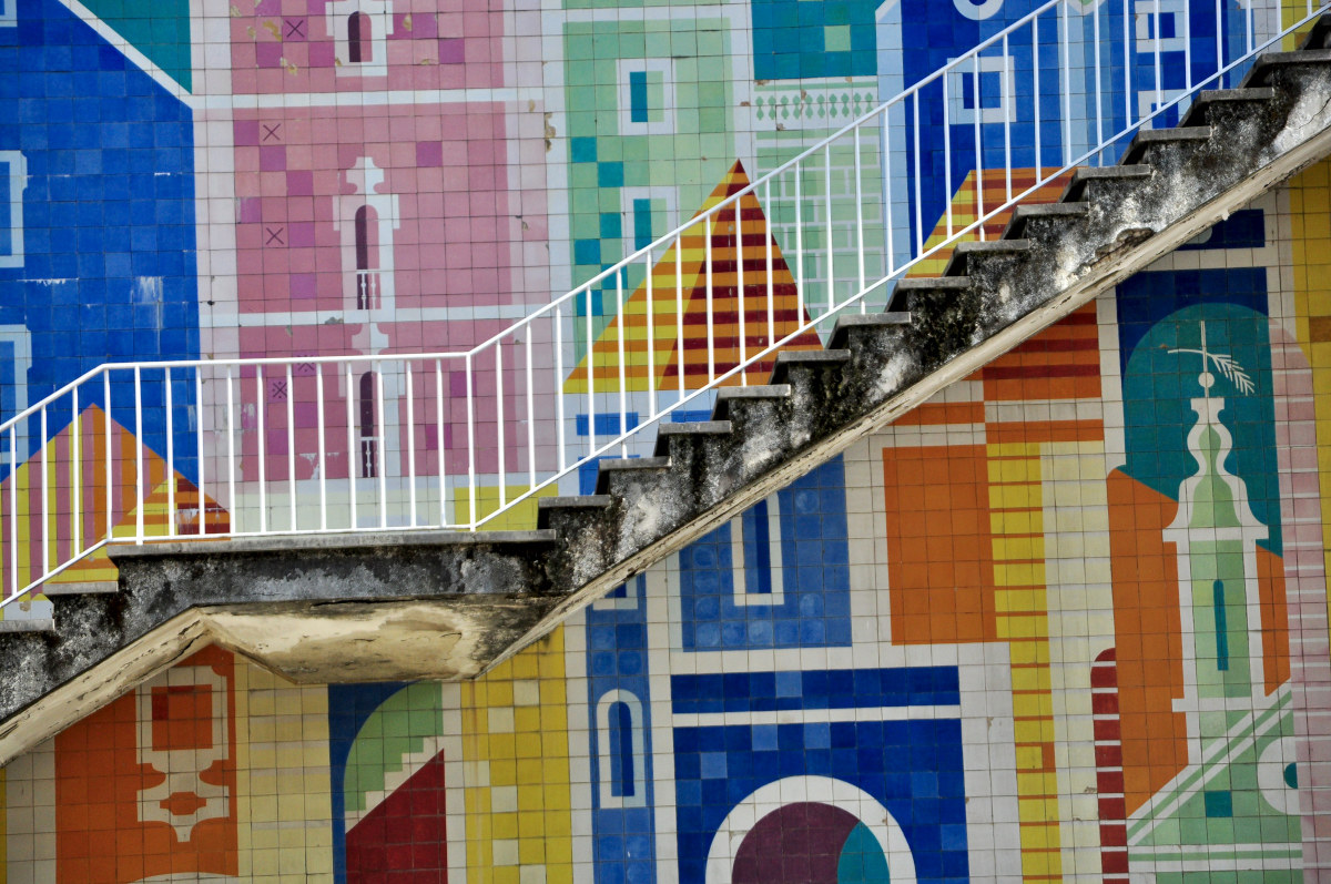 A staircase between two walls decorated with azulejos.