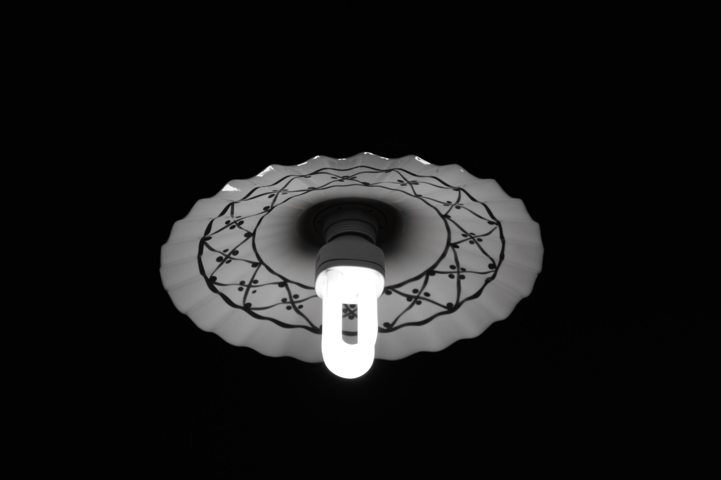 Contrasto tra lampadario antico e lampada a risparmio