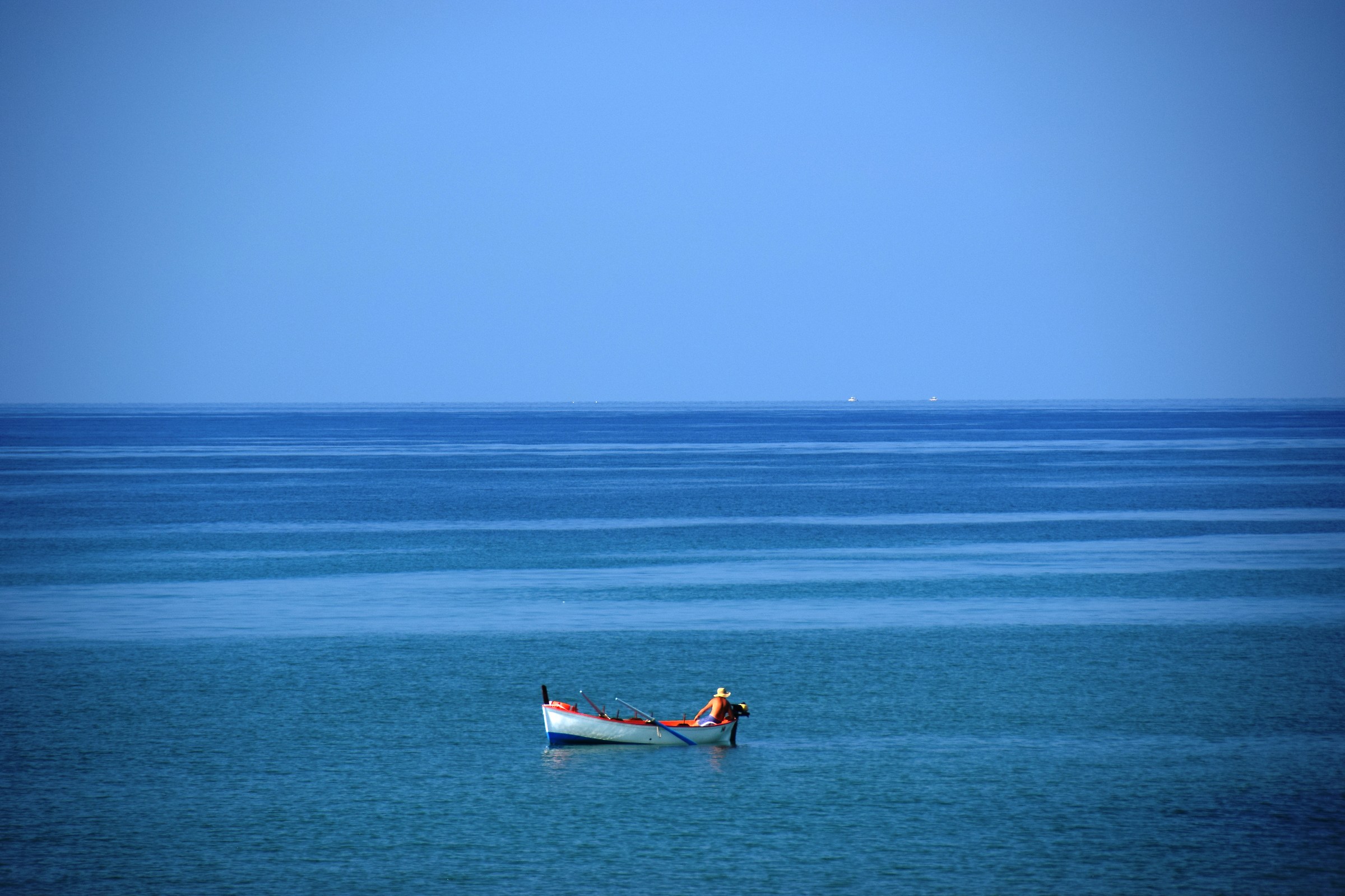 fisherman .... in blue sea of ??August in Punta Secca