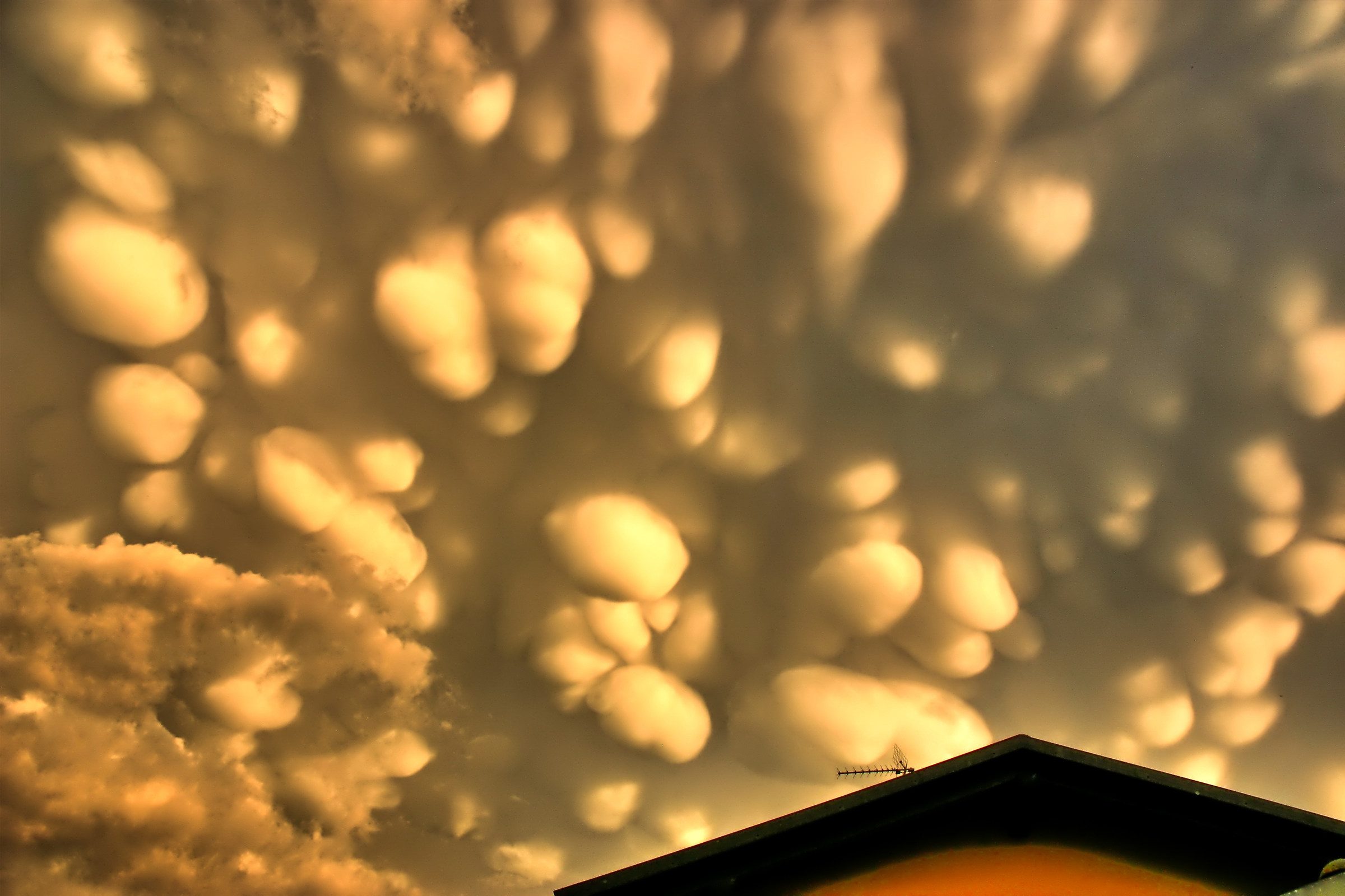 mammary clouds on the roof of the house