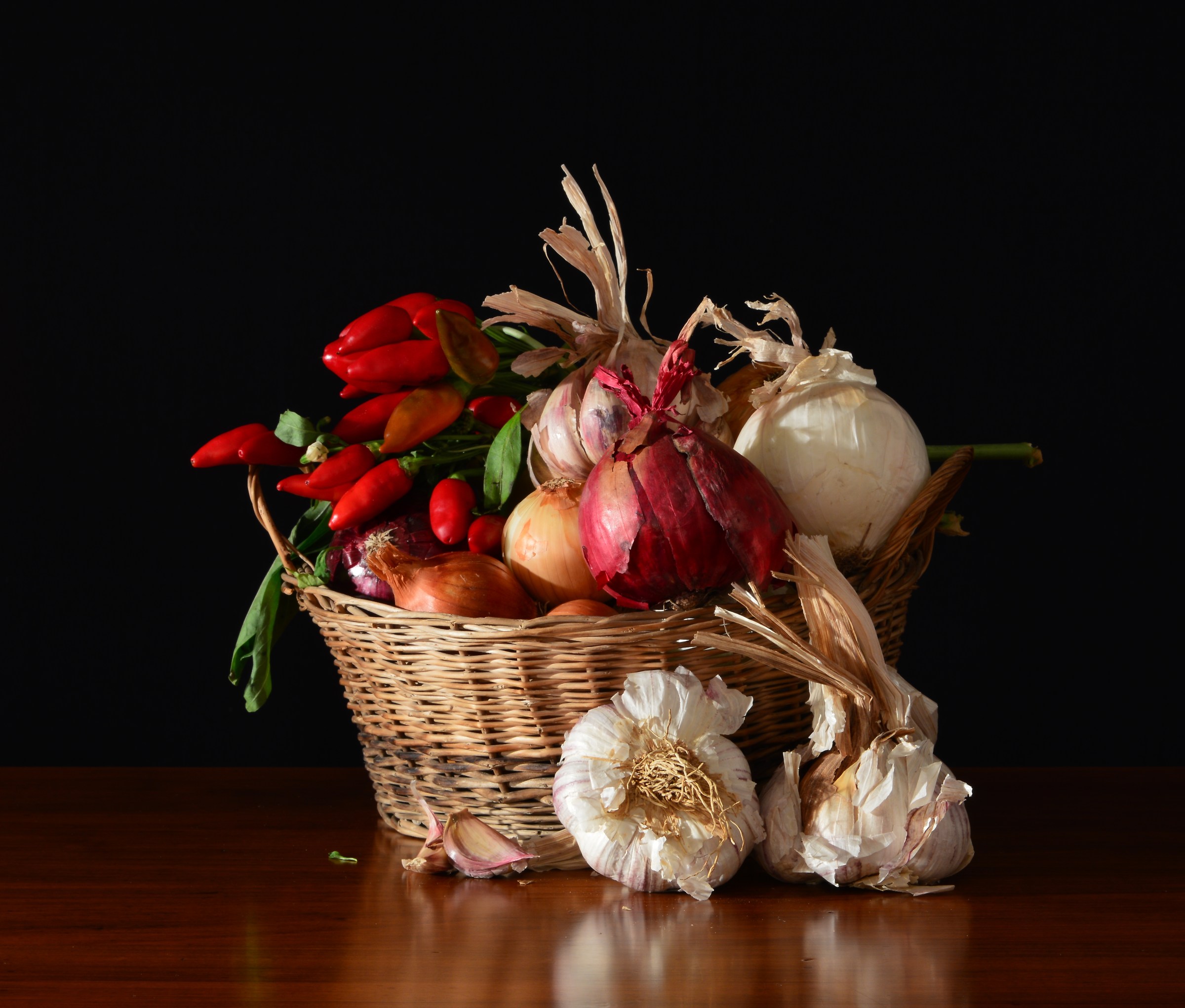 Basket with garlic on a dark background