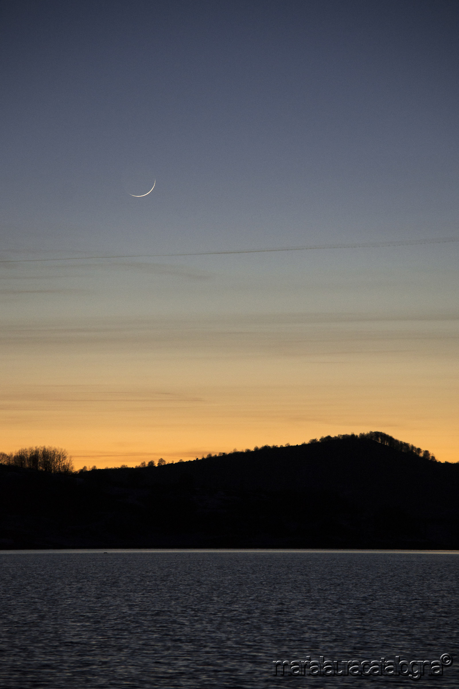 Lago di Campotosto al tramonto e sottile luna calante