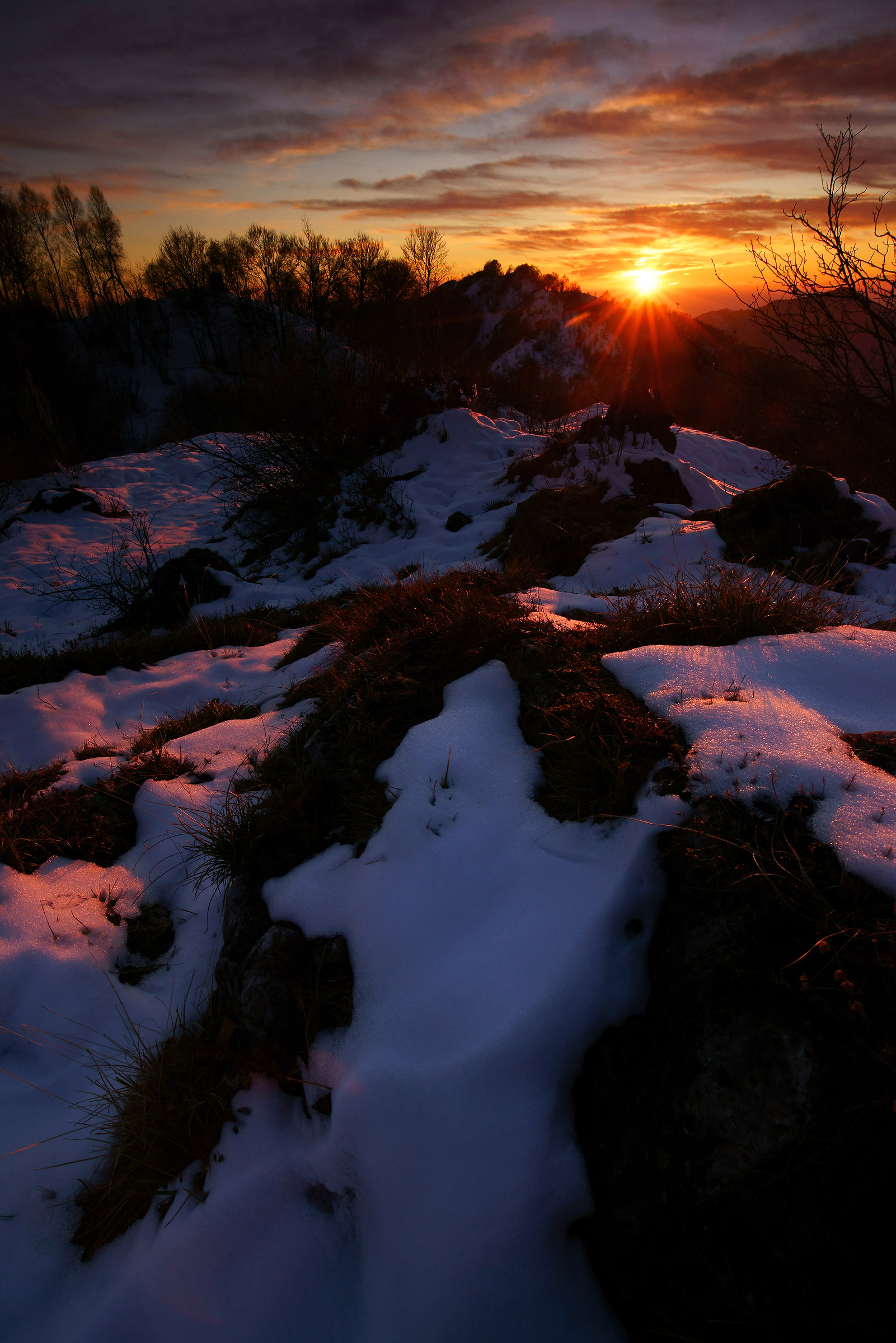 the sun sets and colors the snow