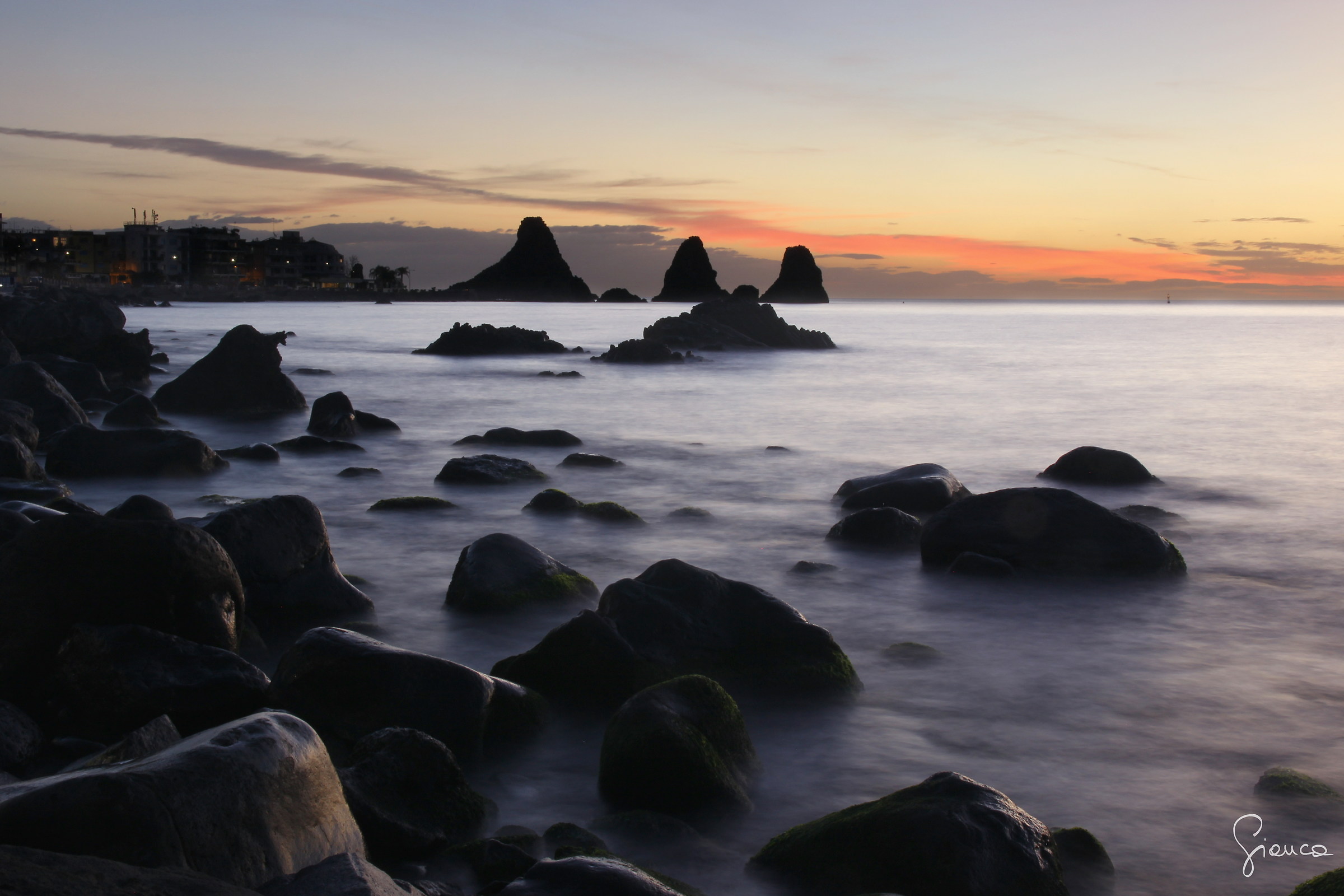 The aurora behind the stacks of Acitrezza