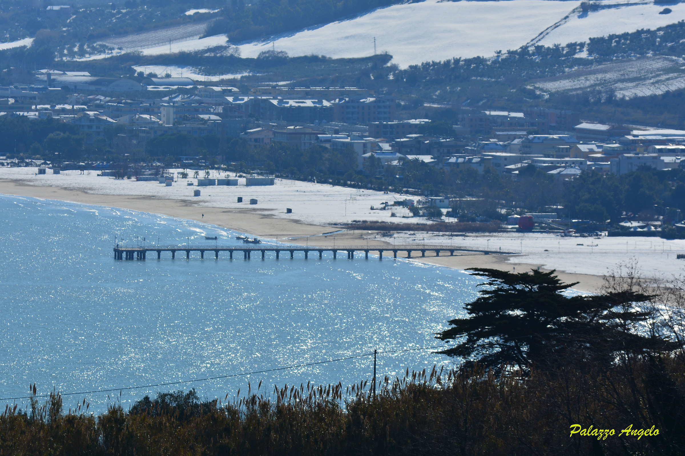Pontile con neve sulla spiaggia