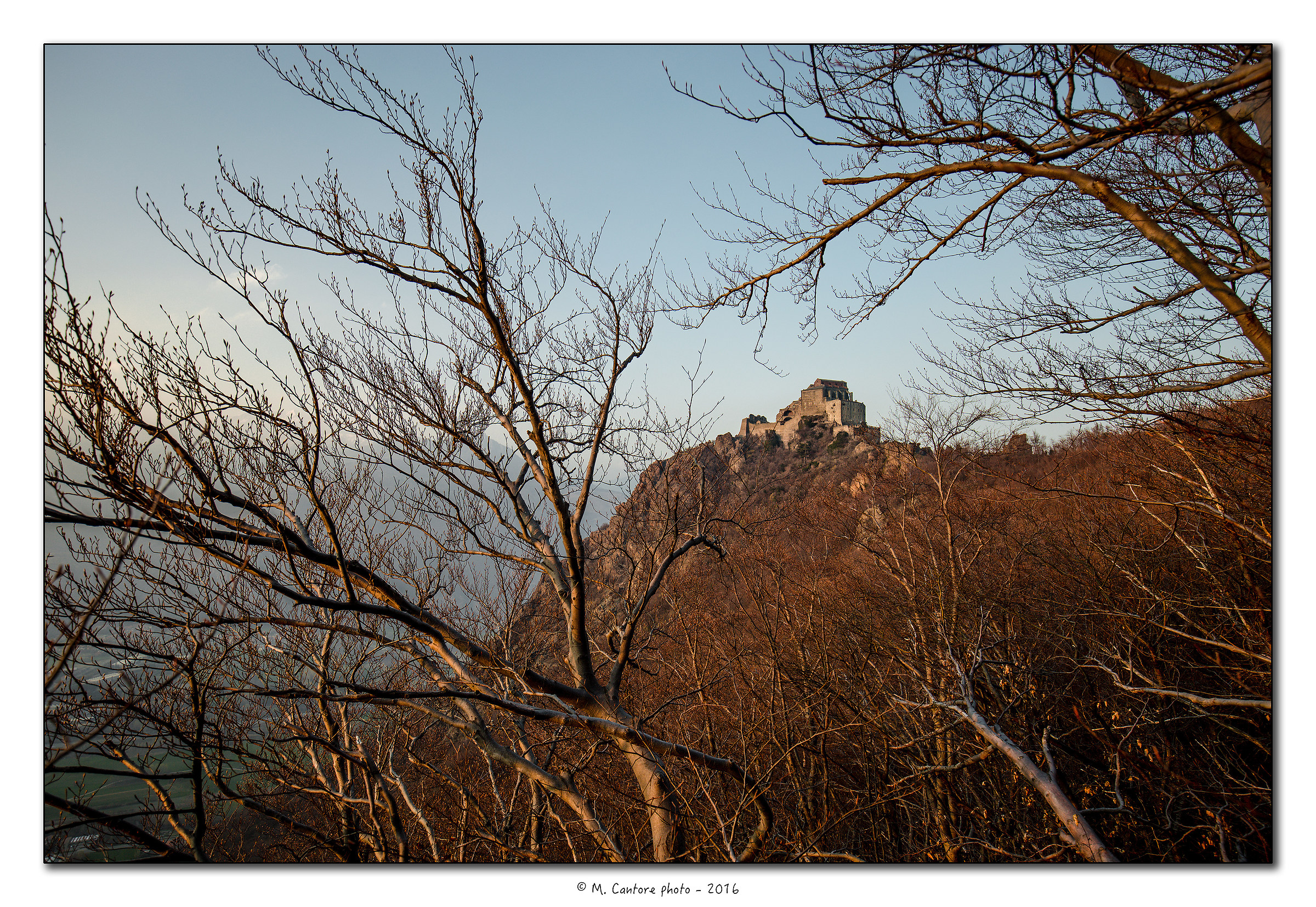 La Sacra al tramonto dal bosco di faggi