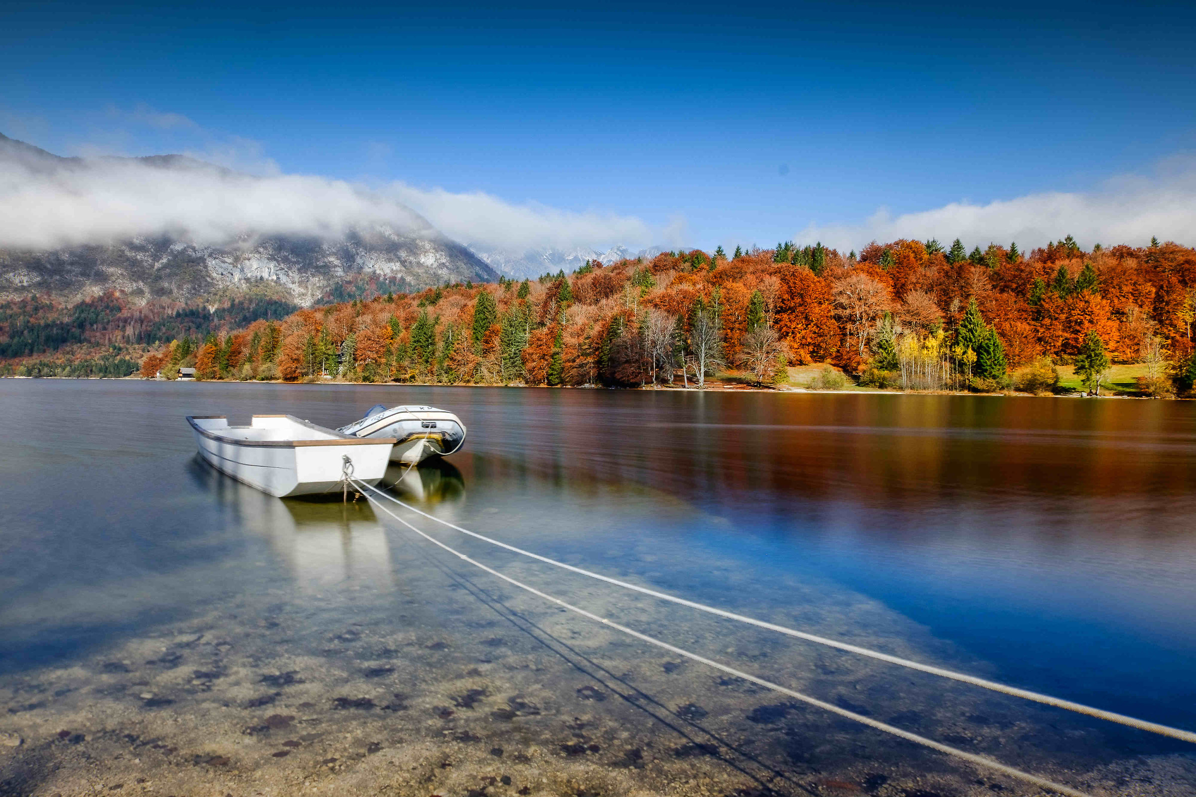 Barche al lago di Bohinj nella nebbia di mattina