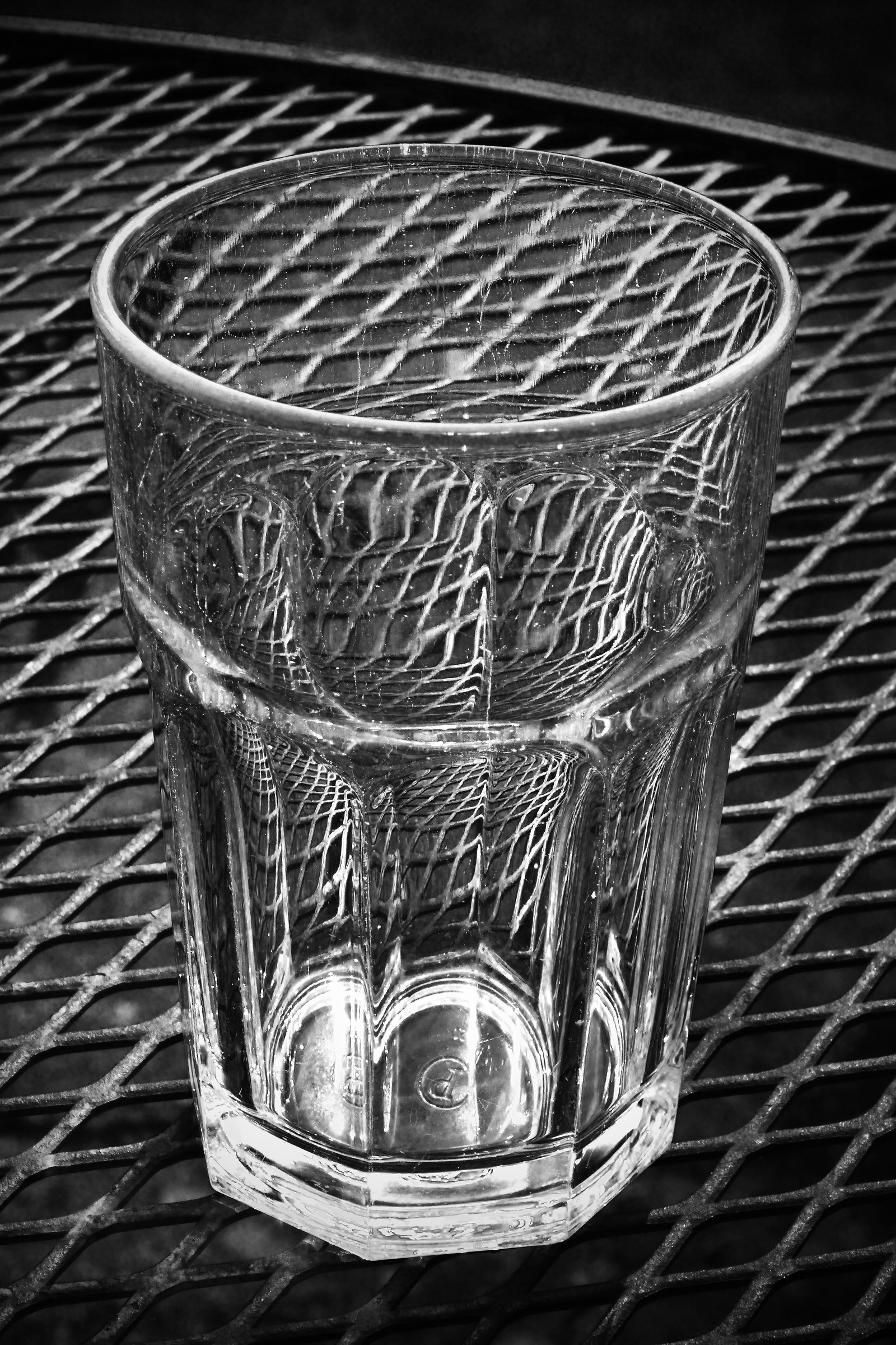 Empty Drinking Glass on the Wire Mesh Table