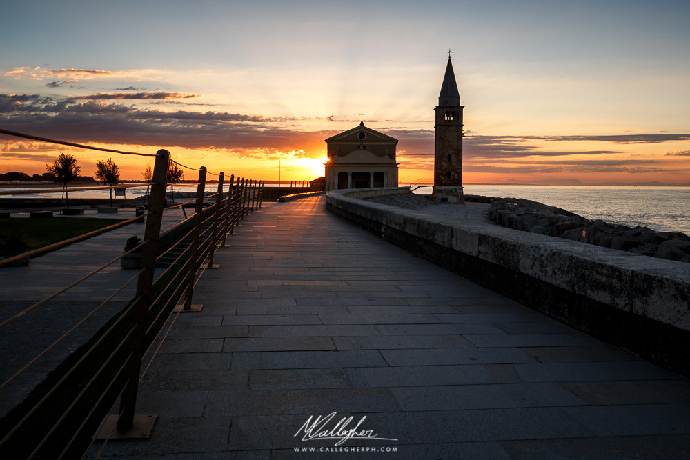 The sun rises behind the church