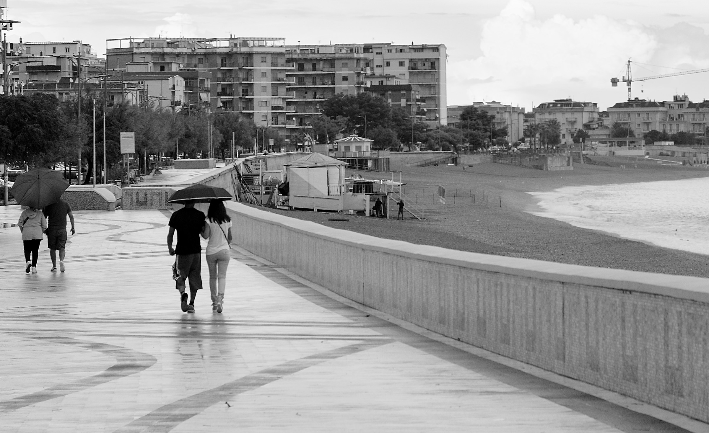 It rains in the summer end, the promenade of scattered umbre...