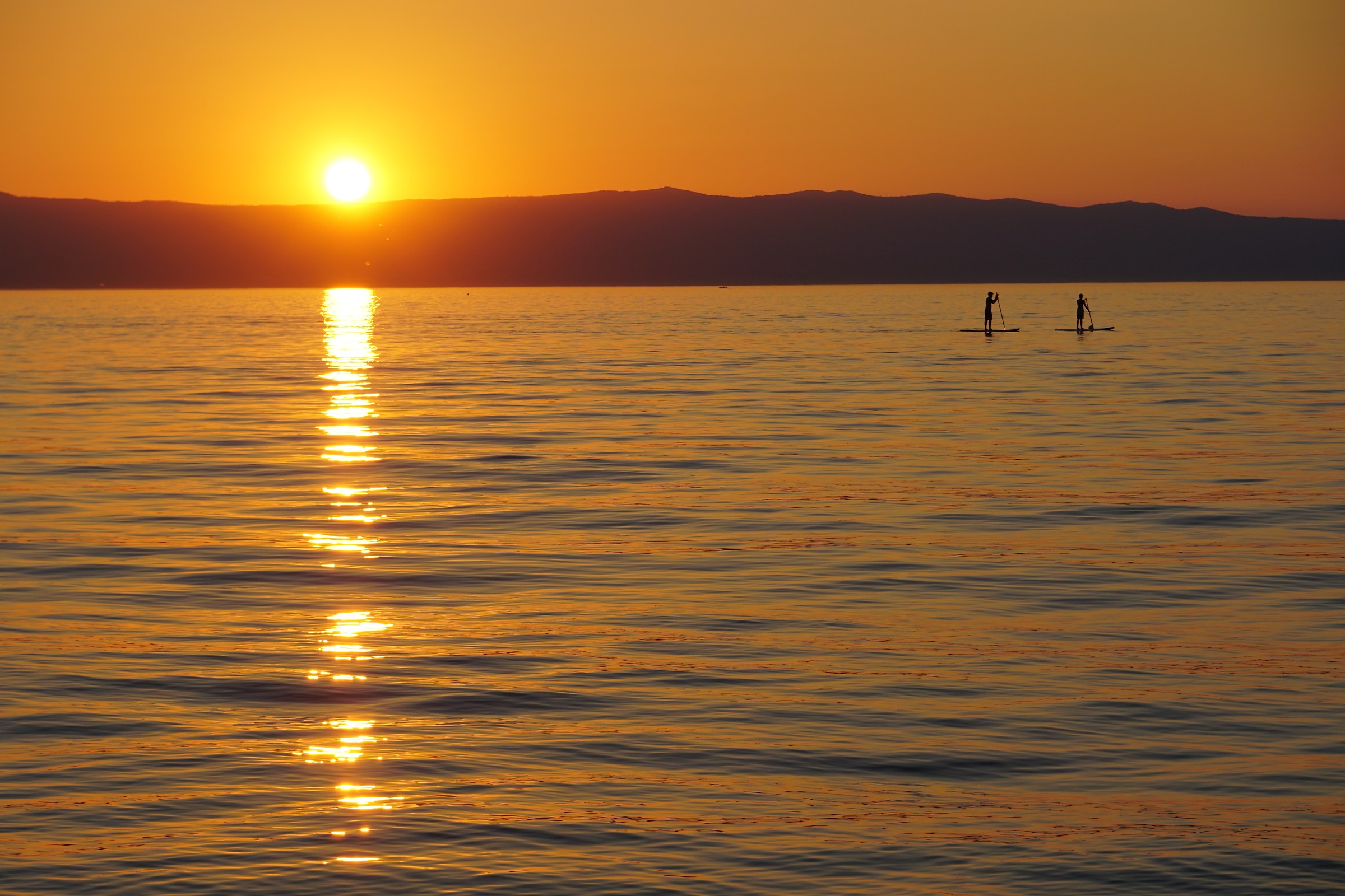 In piedi sul mare al tramonto