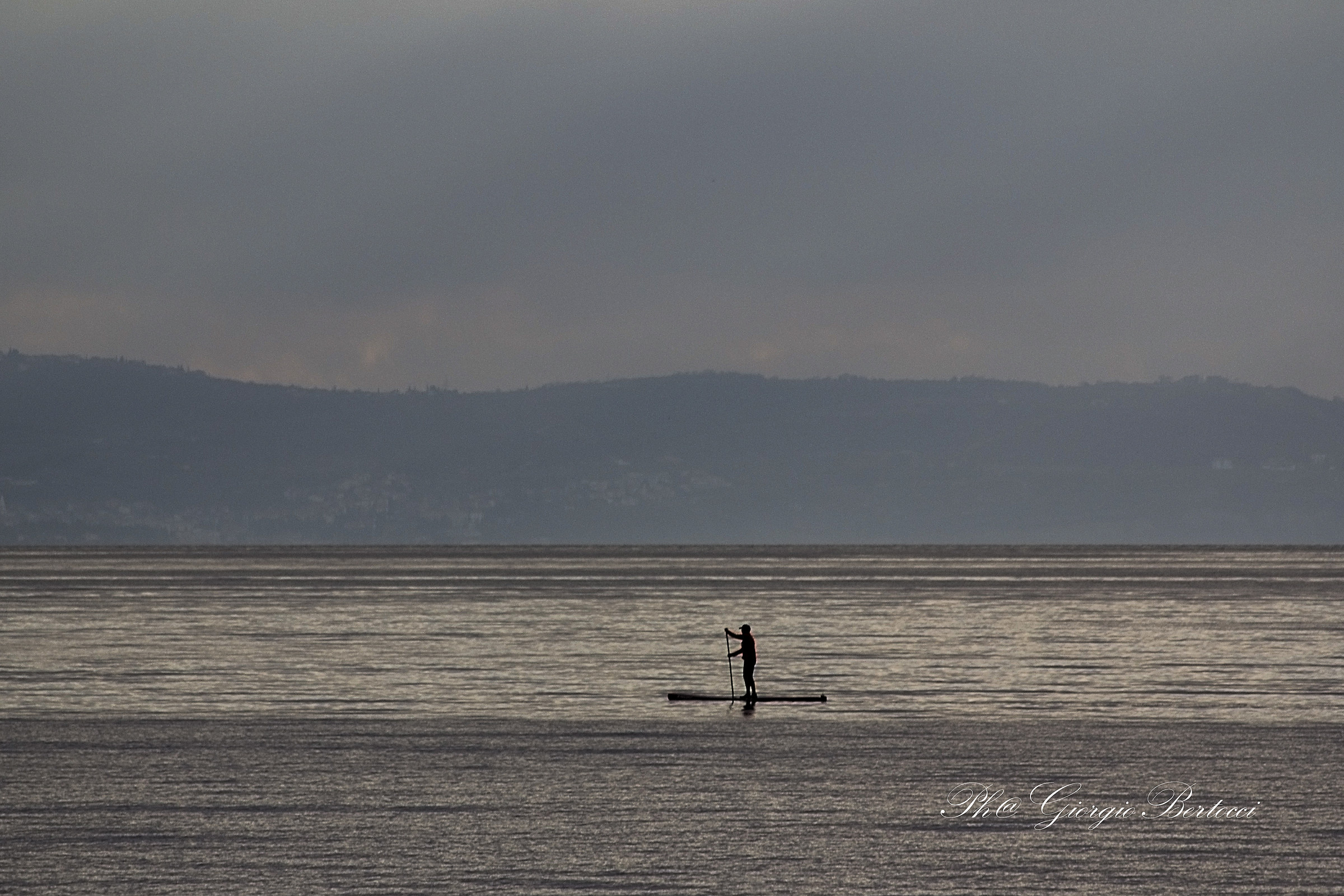 Lonely man paddling in the sea Trieste Barcol