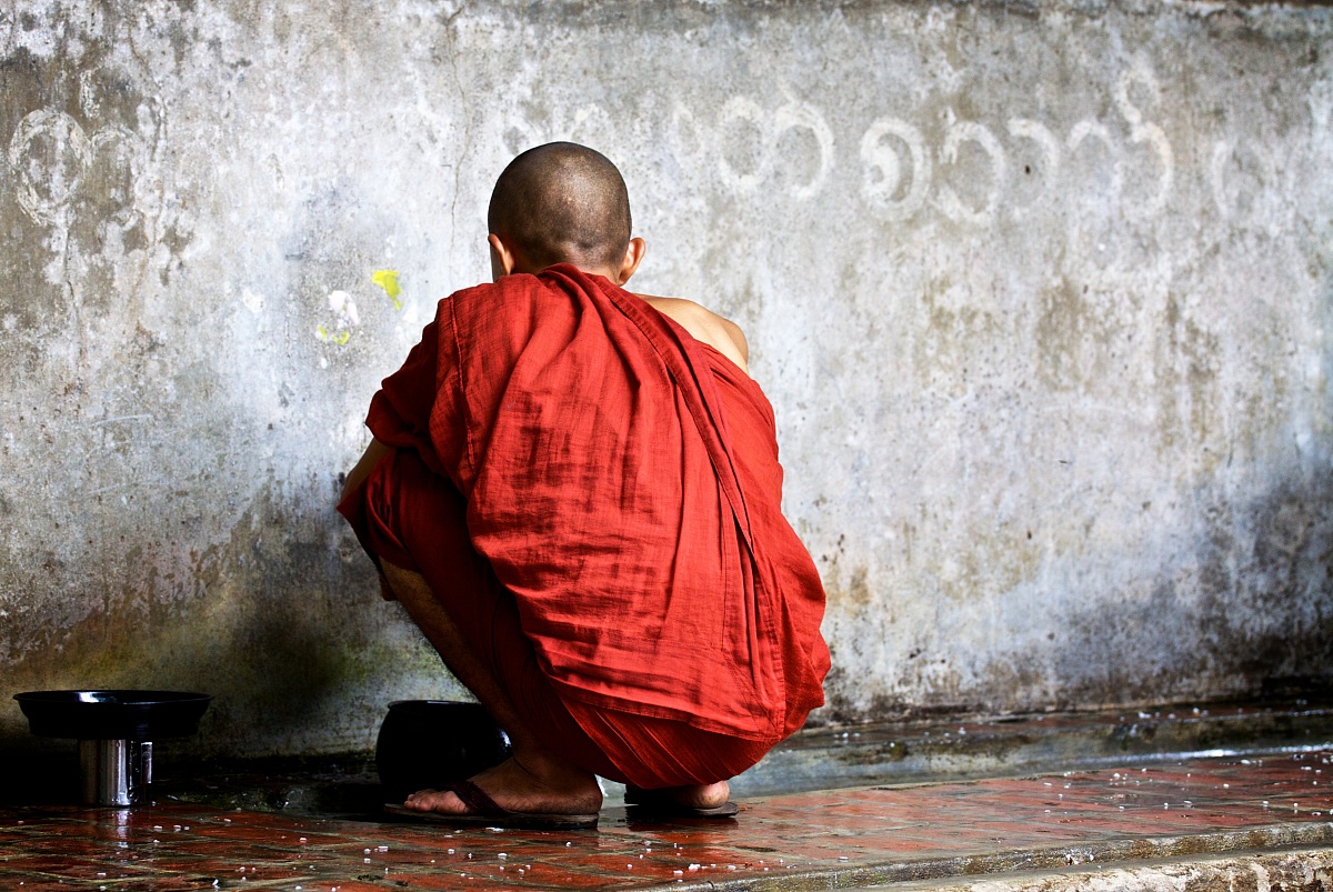 Birmania - Un giovane monaco lava la pentola del pasto