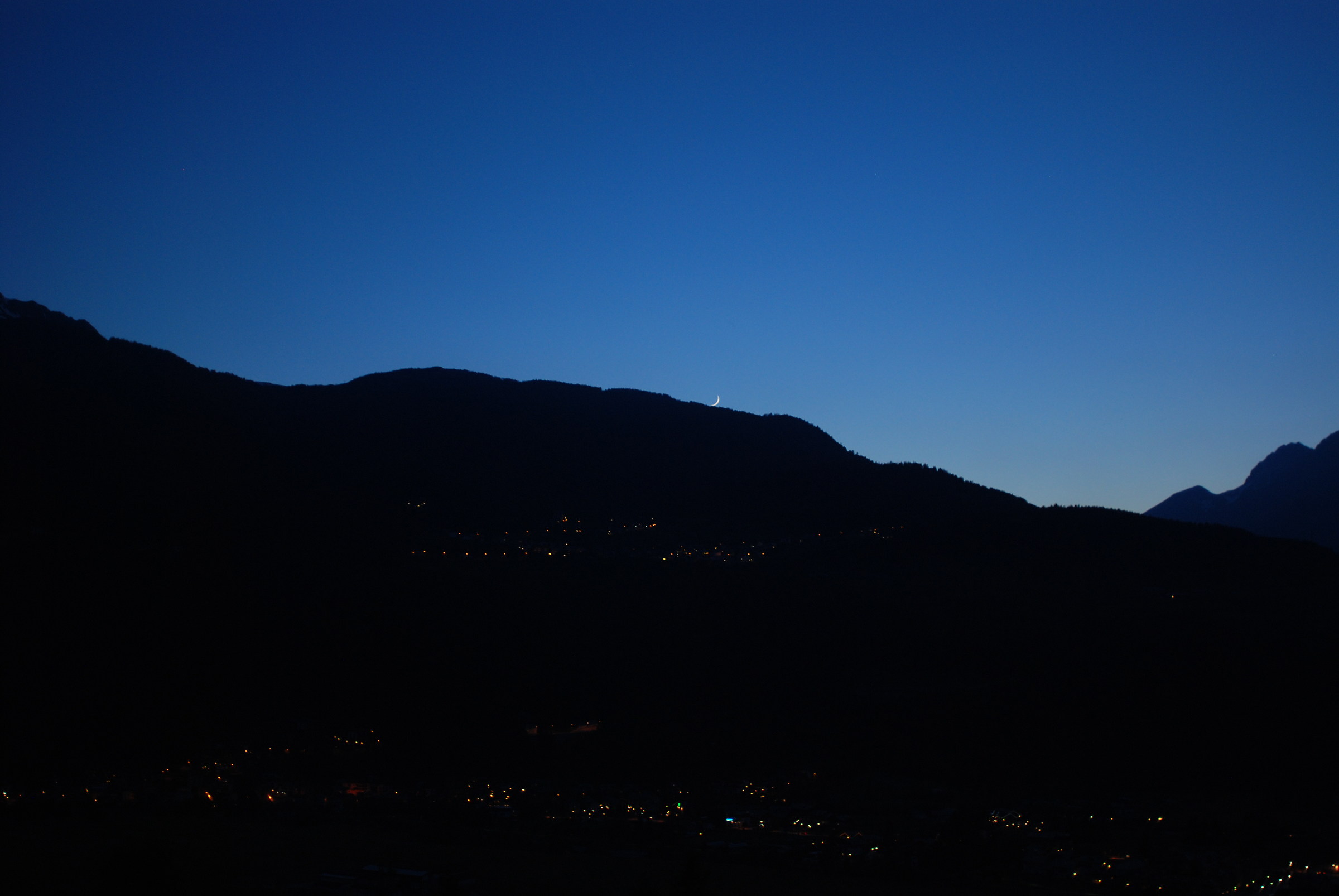 The moon emerges from the mountain