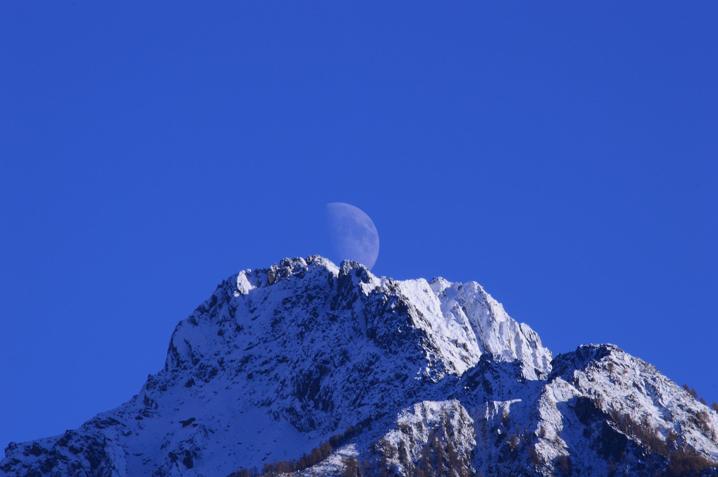 The moon emerges from the mountain
