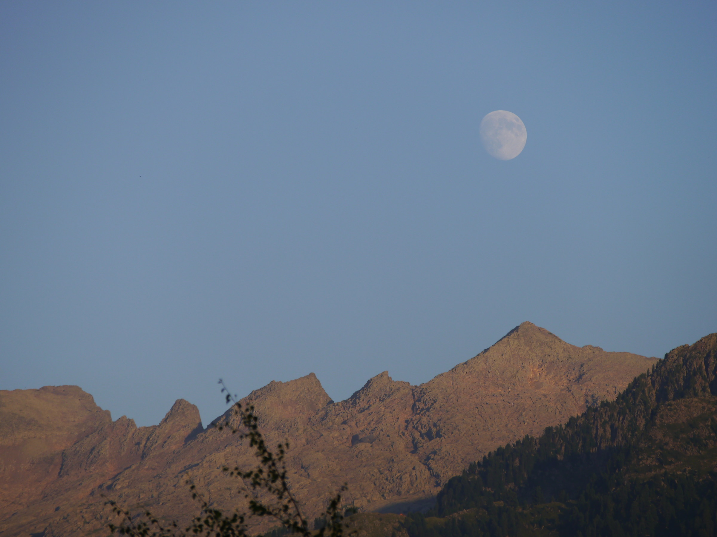 The moon emerges from the mountain