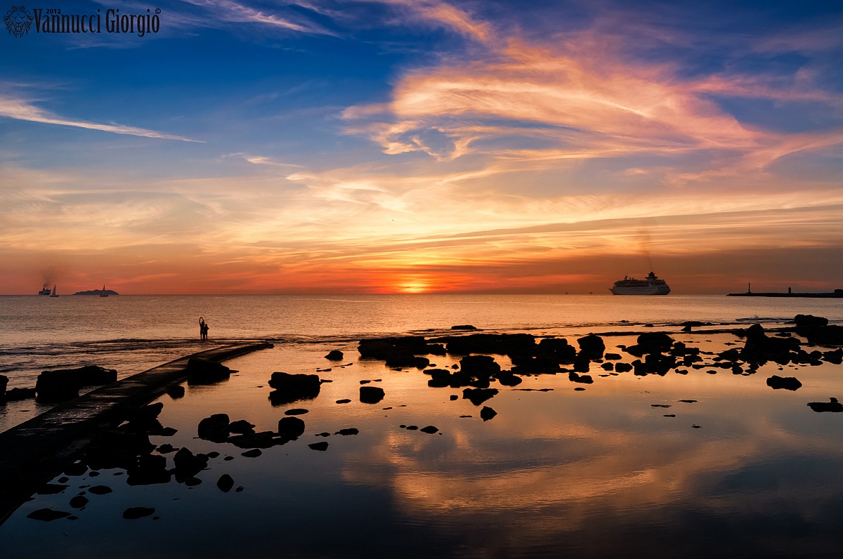 Mare, riflessi e uomini al tramonto