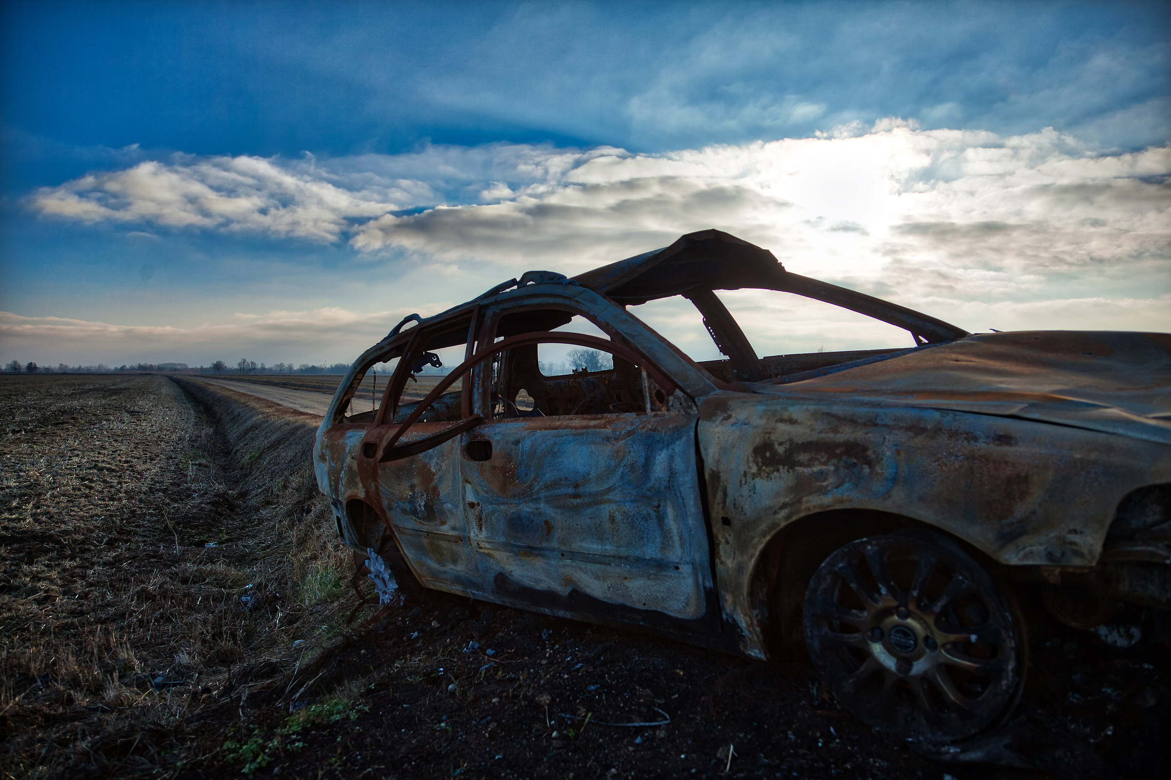 Auto abbandonata sole velato frontale