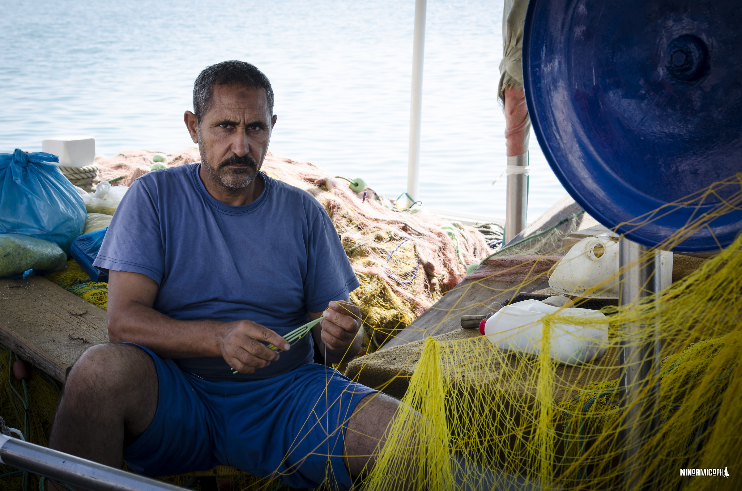 fisherman repairs fishing net
