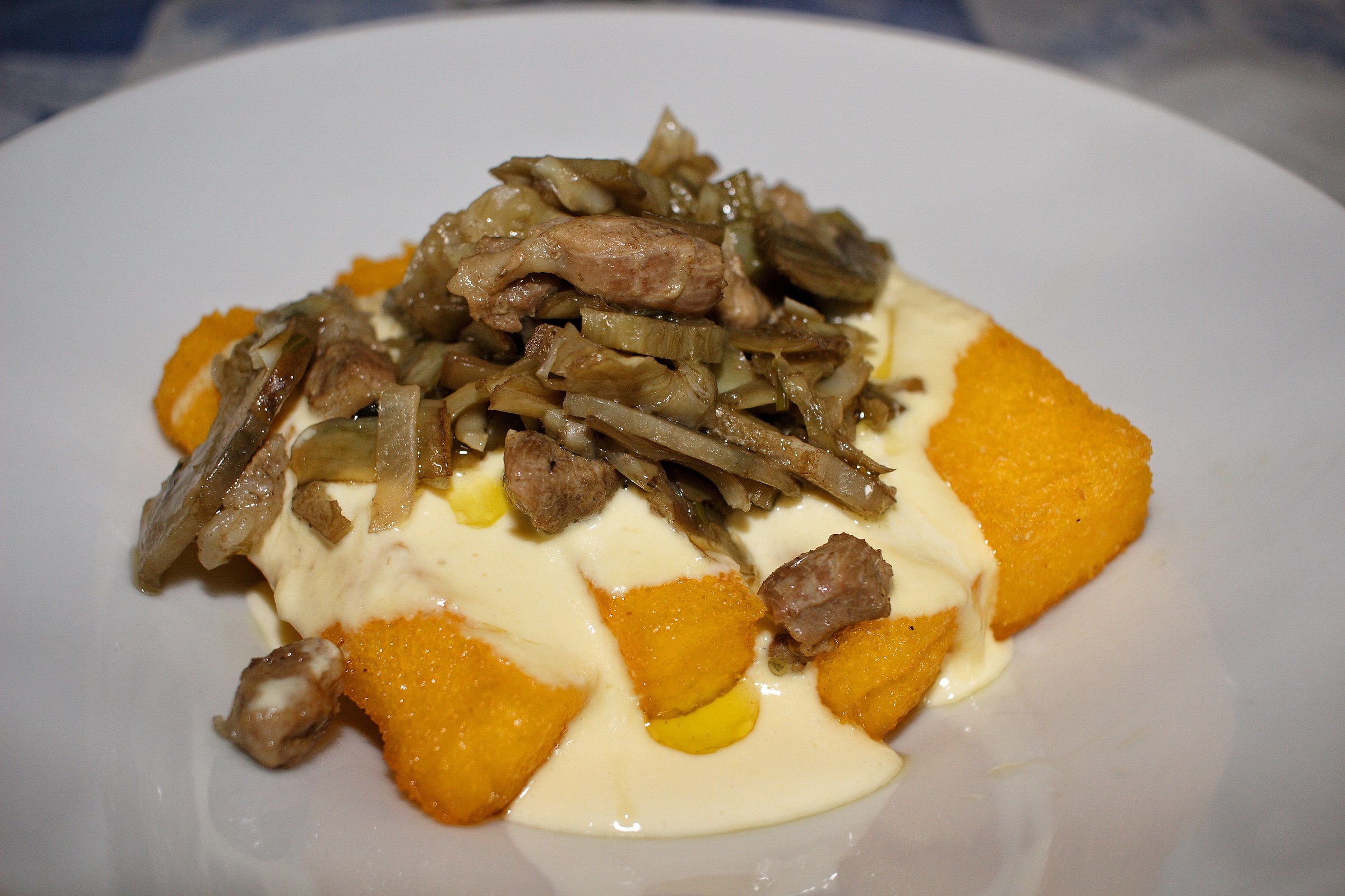 Polenta with artichokes and bacon in parmesan cream