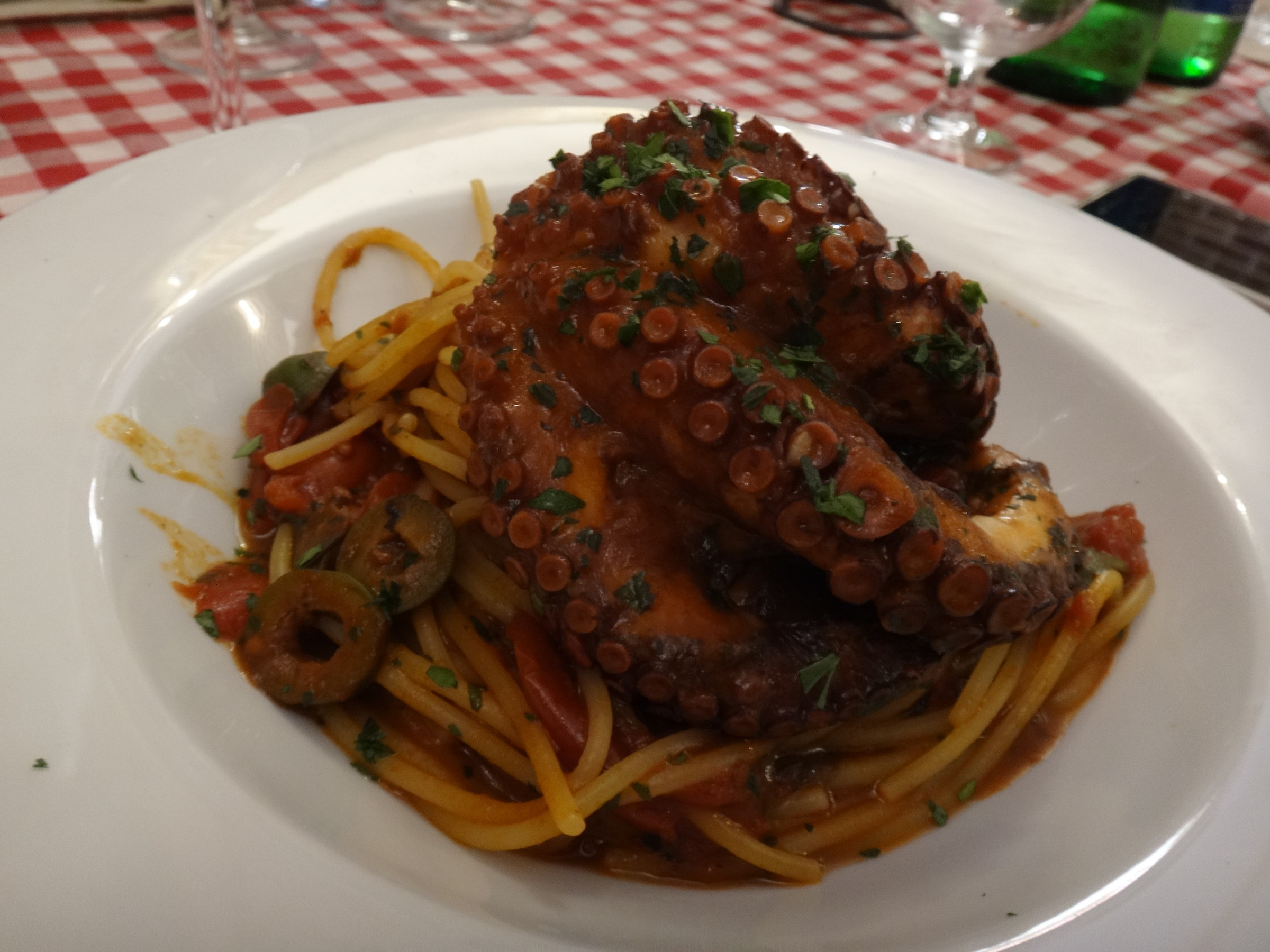 Spaghetti with octopus drowned in tomato sauce