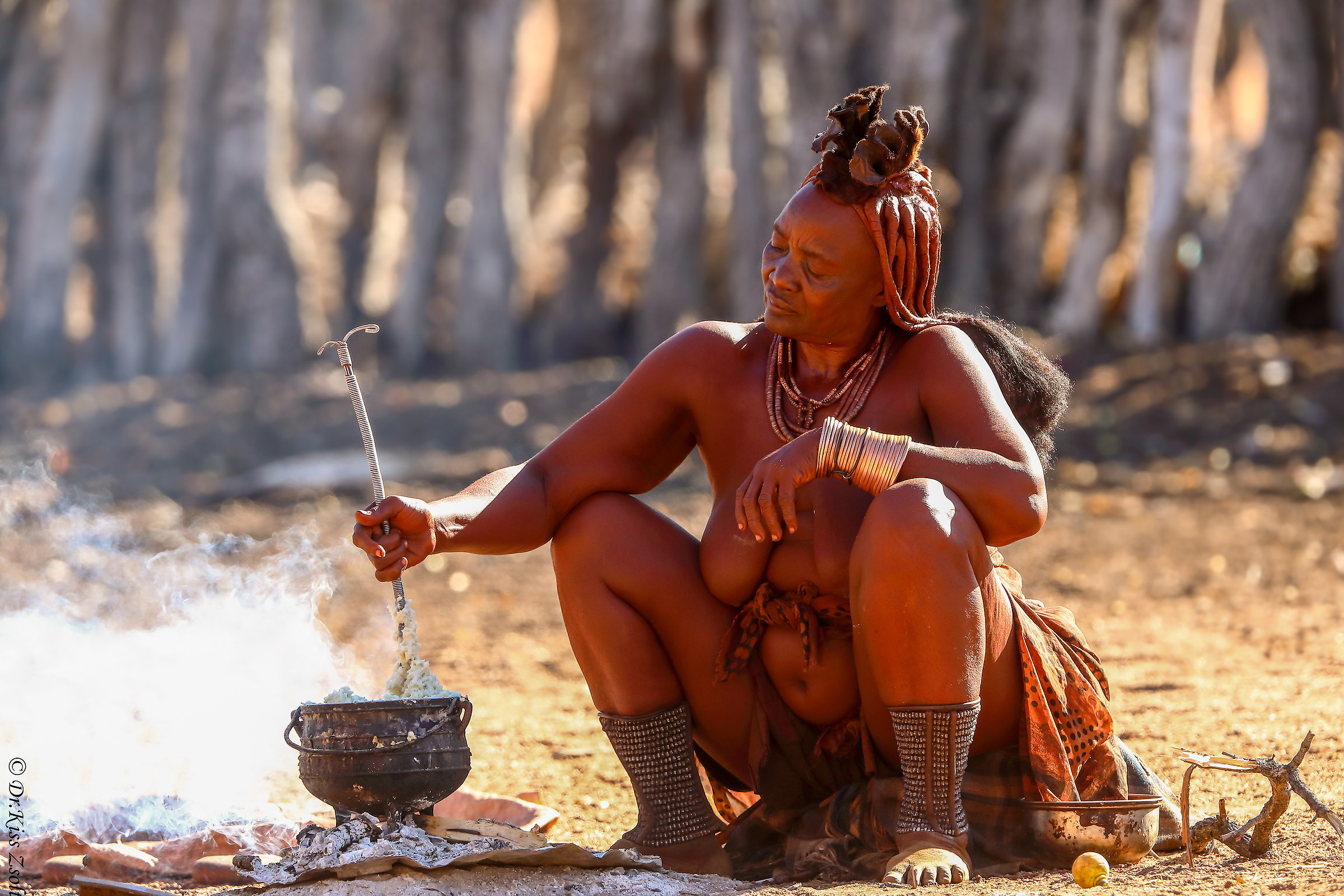 Elderly himba woman, cooking her meal