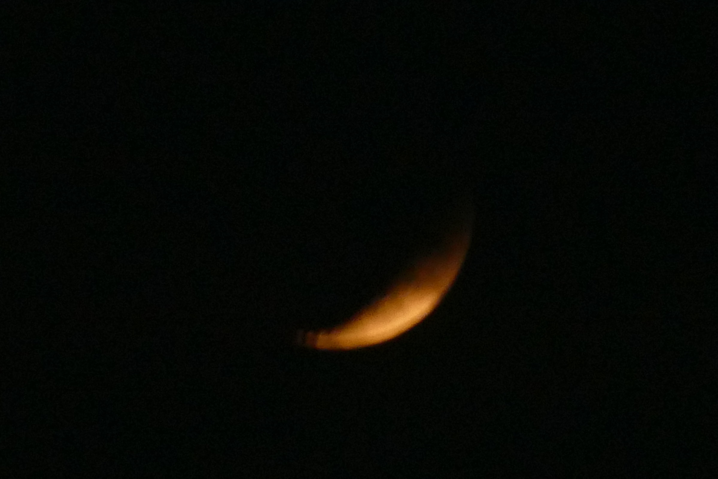 spicchio di luna coperta da nuvola