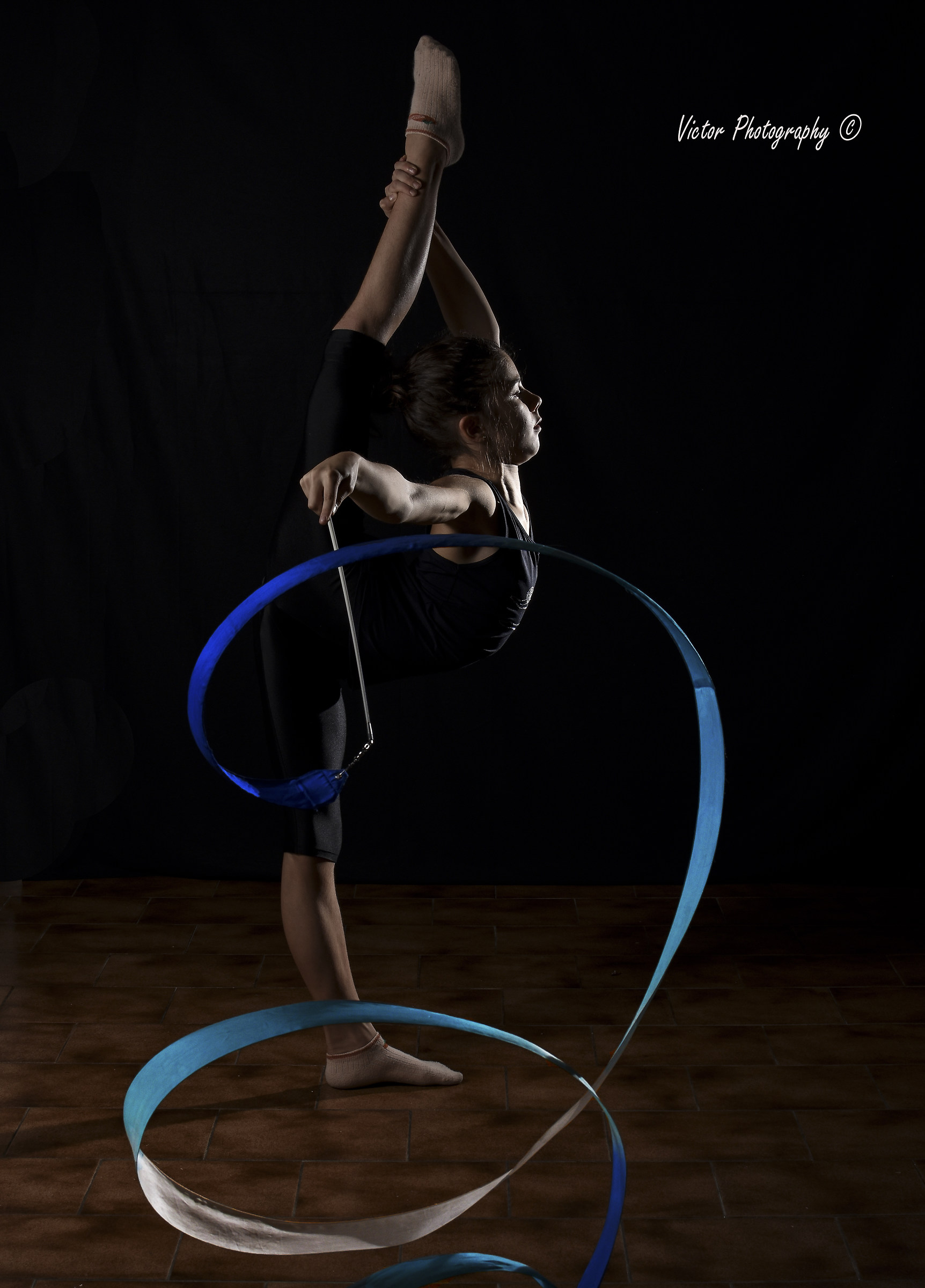 La ginnasta con nastro sotto la luce