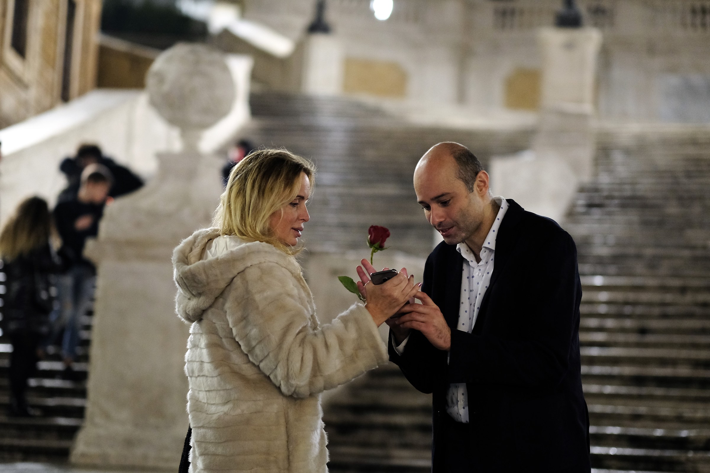 Holding a rose, the teledfonine in the other