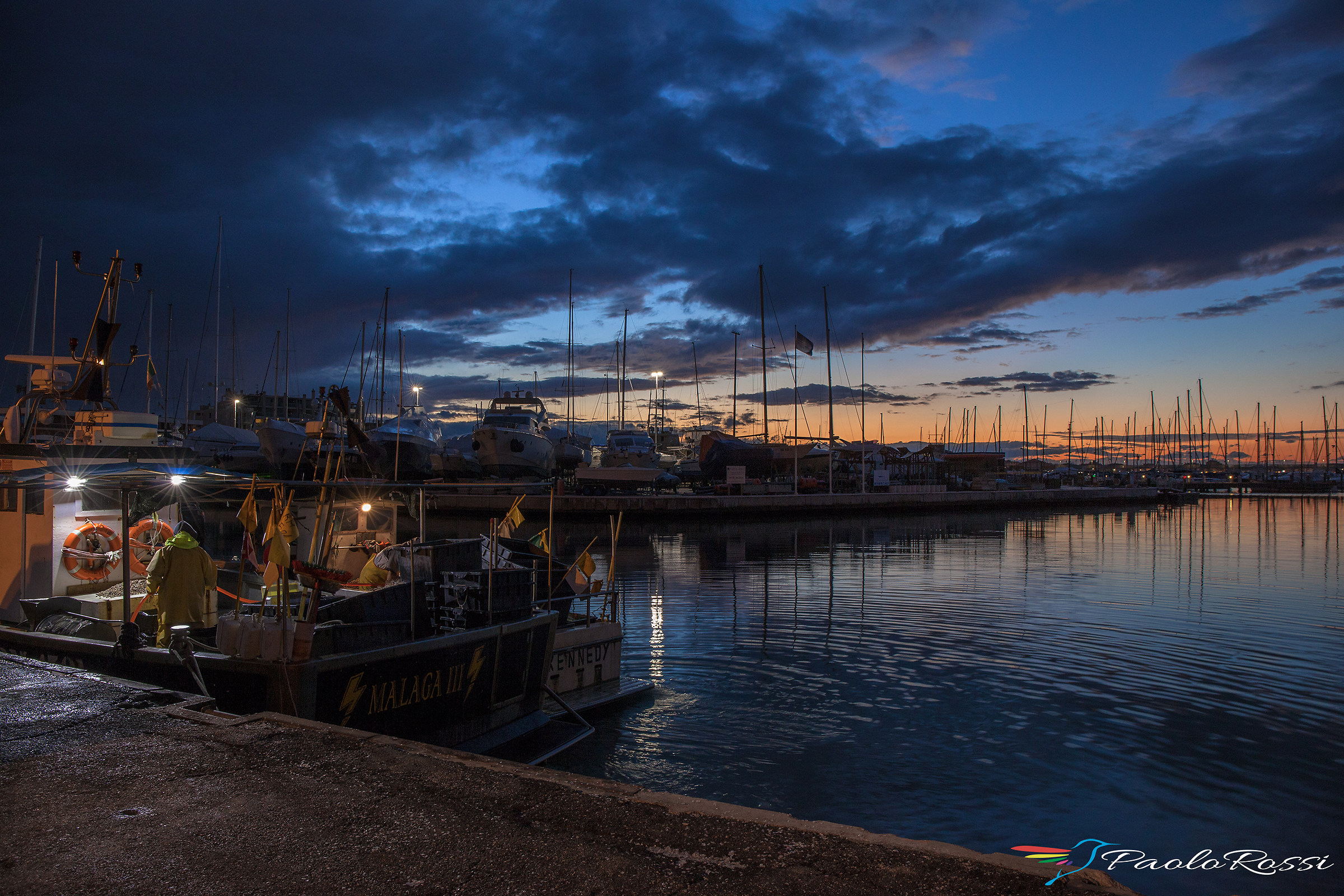 Pulizia delle lumachine di mare al tramonto