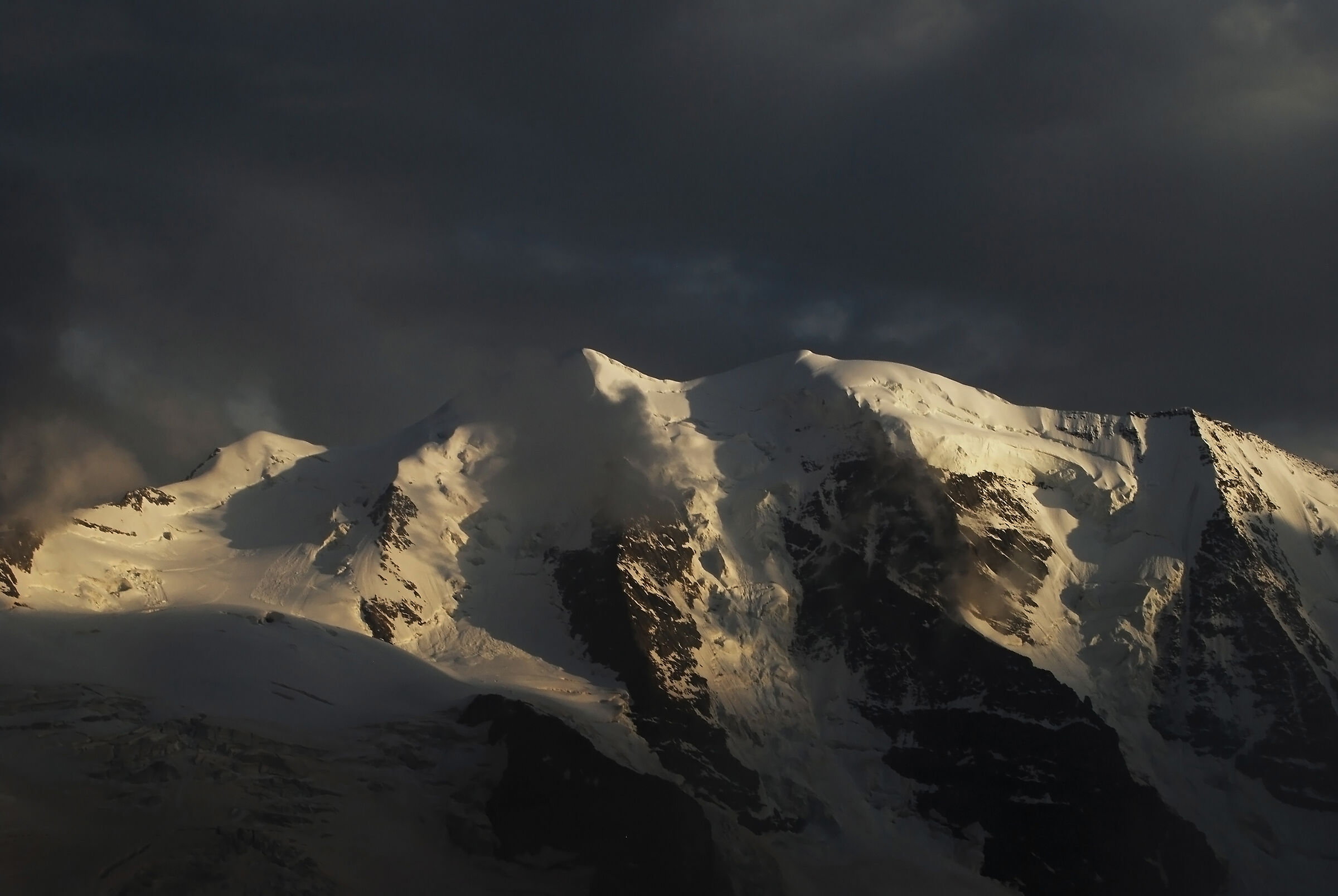 Piz Palü soleggiato e sovrastato da nuvole minacciose