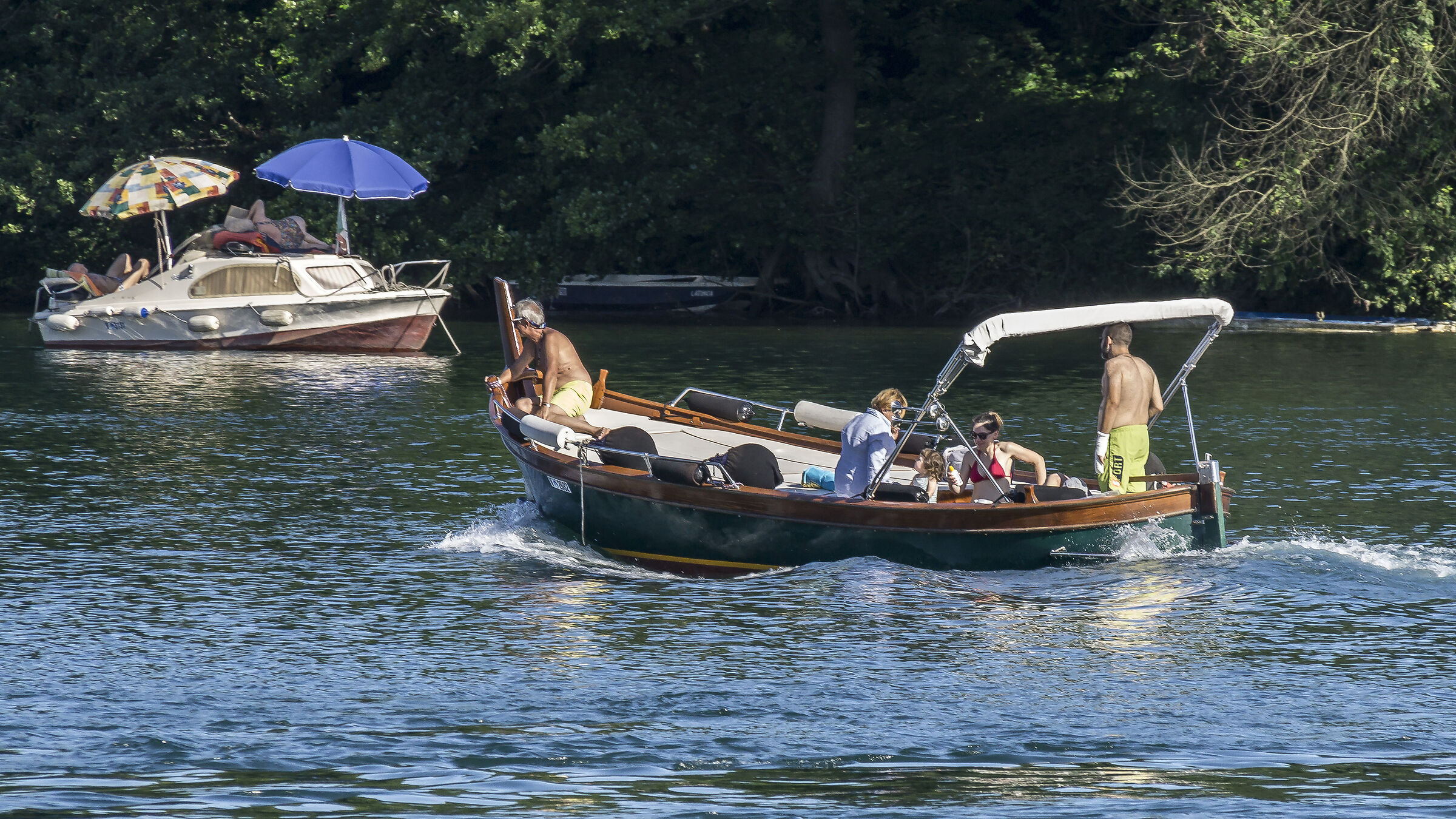 Gozzo che incrocia una pilotina con due ombrelloni