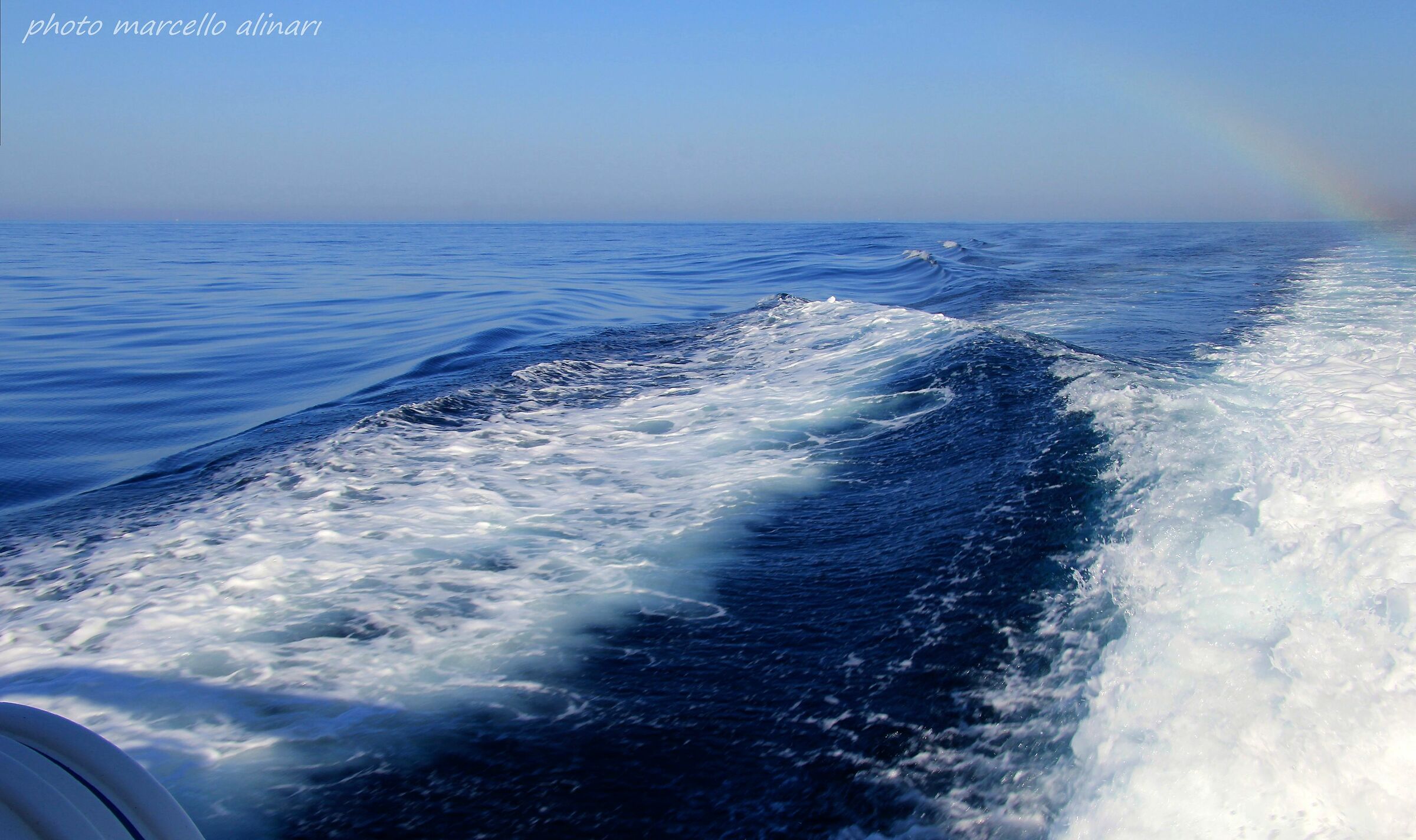 Un timido arcobaleno oltre la scia