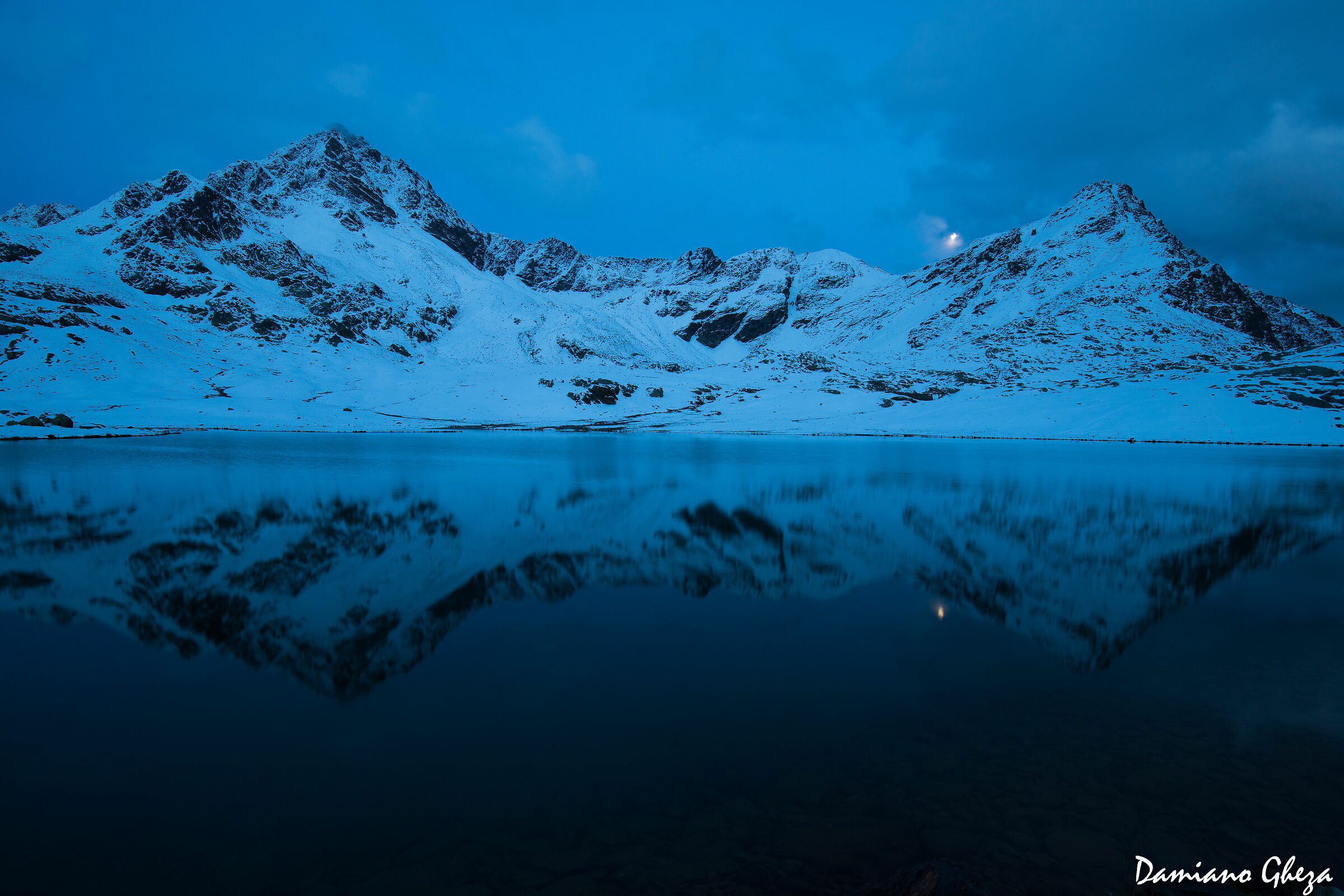 La luna sorge e si riflette nel lago