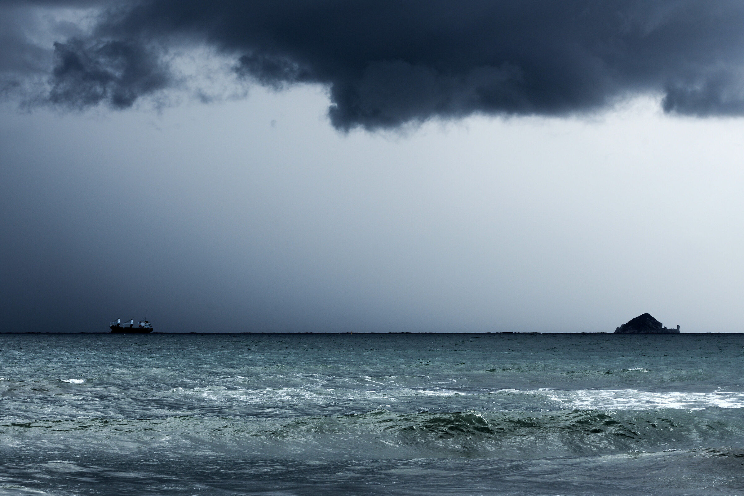 A distant ship smoke on the horizon