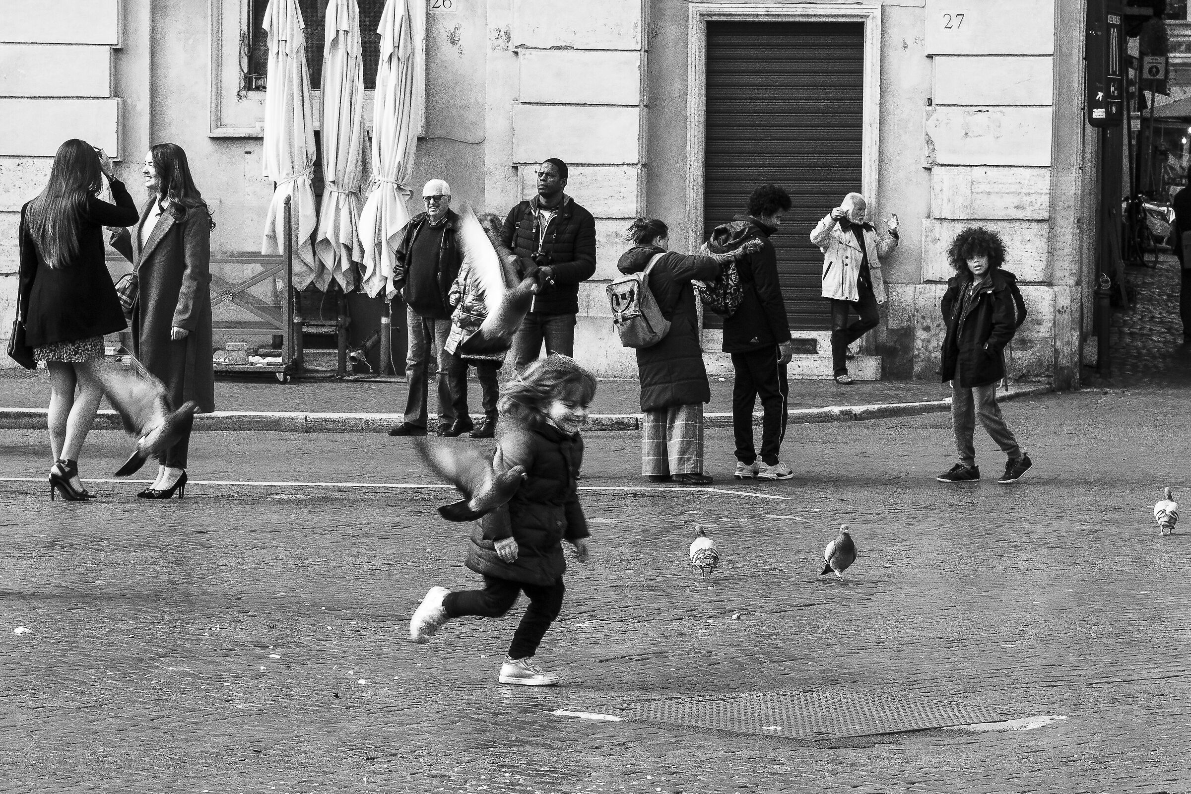 Bimba con i piccioni in volo