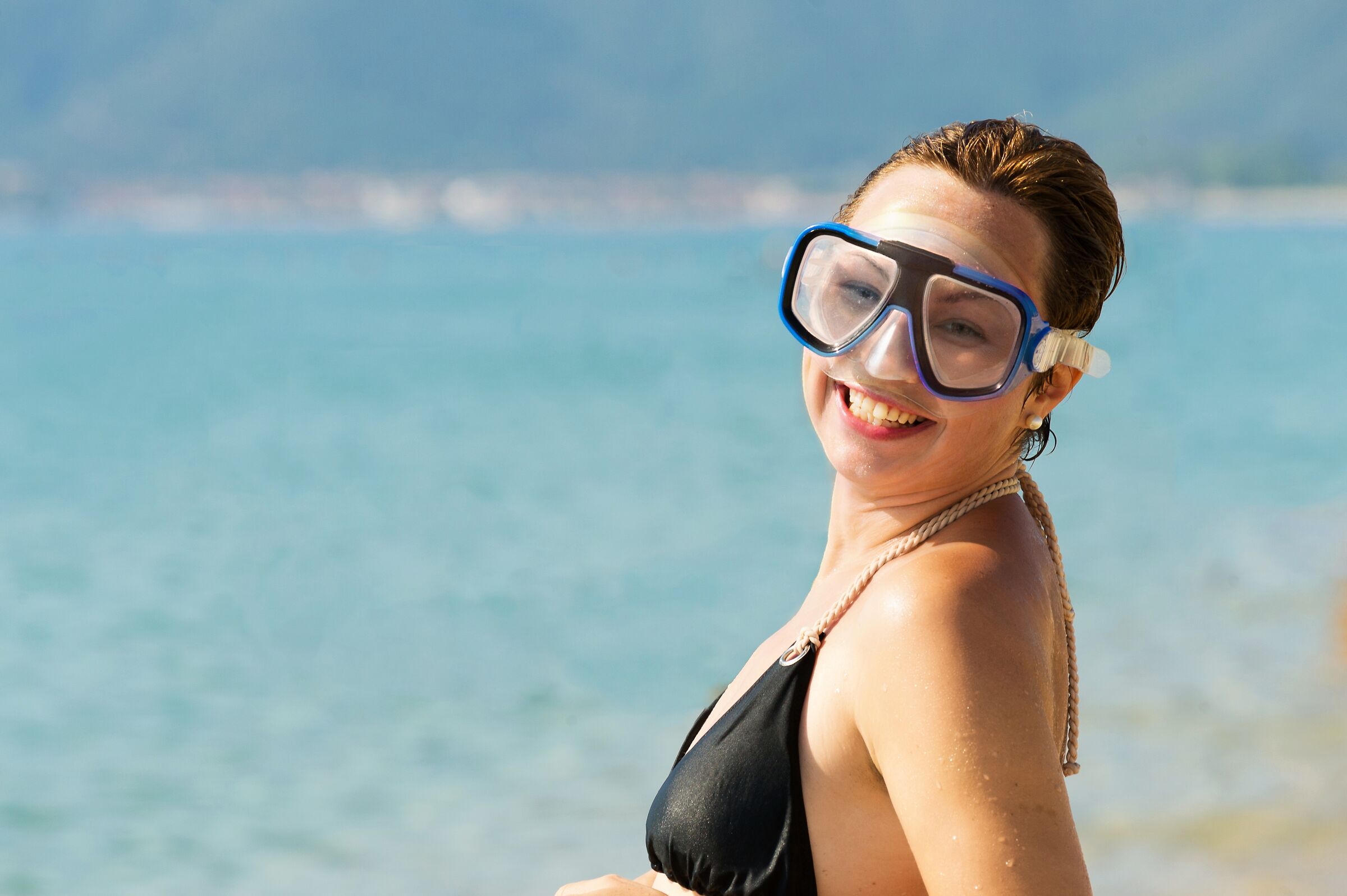 Young woman with scuba diving glasses on the beach