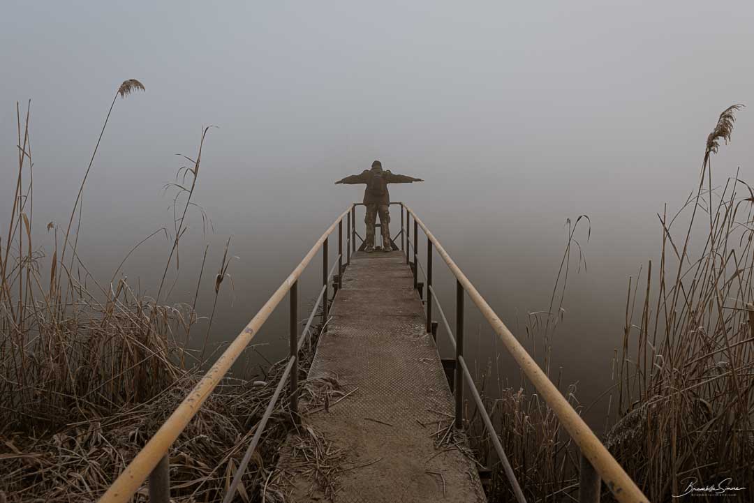 Man with open arms on a frozen pier