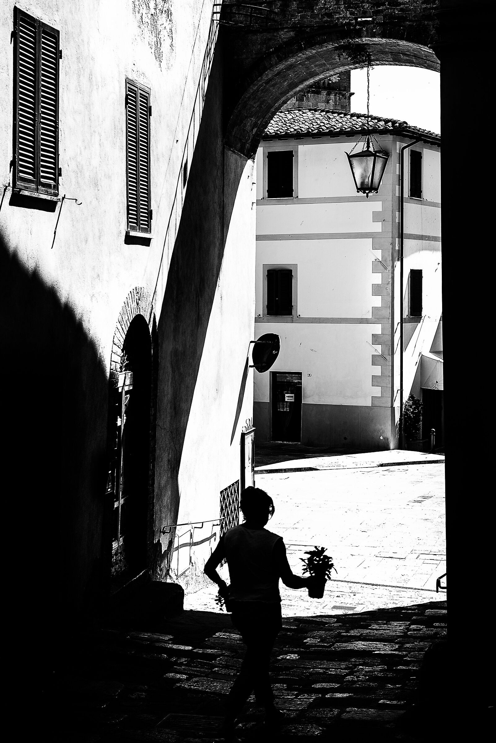 donna con fiori in un vicolo di cetona(si)