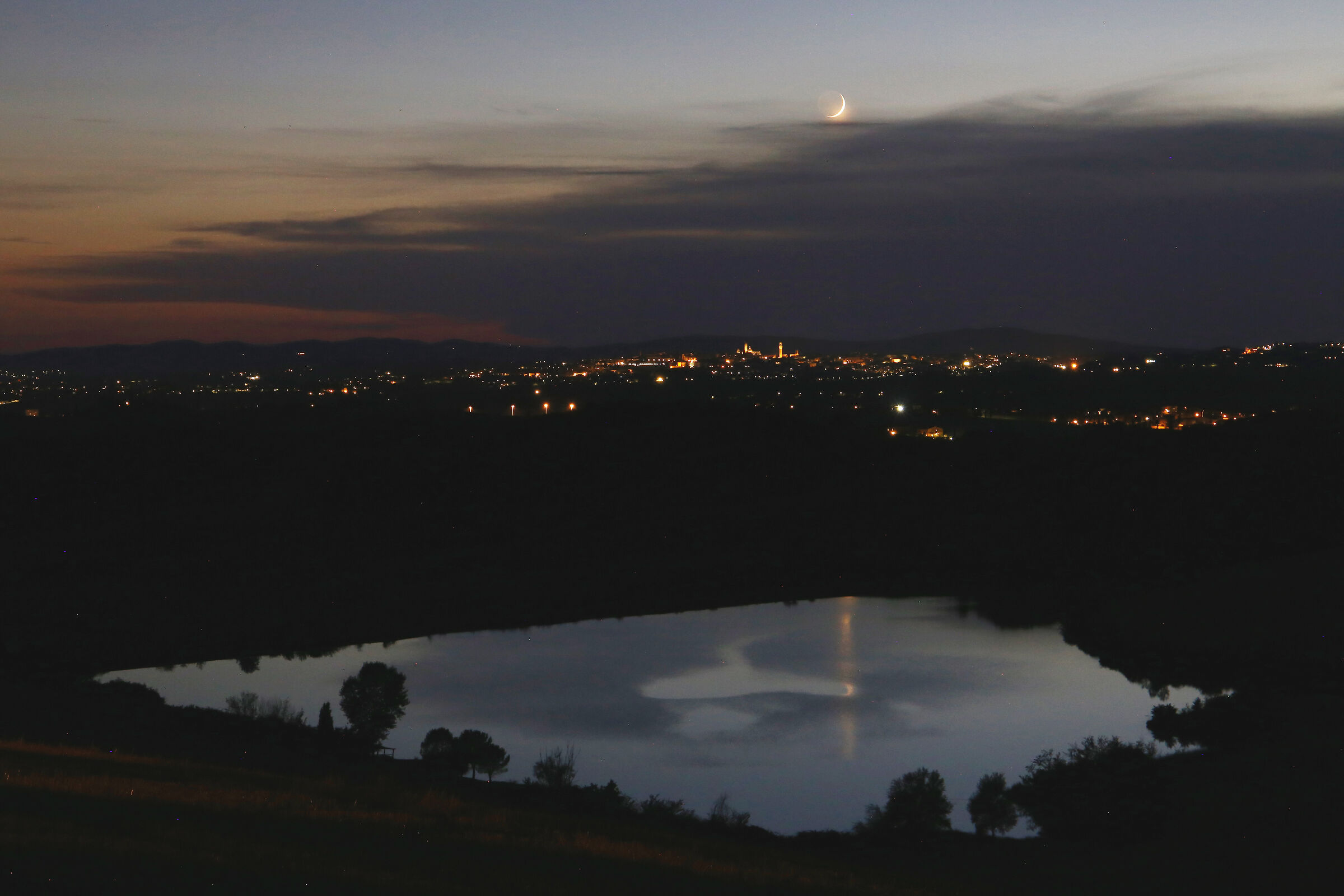 Luna cinerea prossima al tramonto, sopra Siena