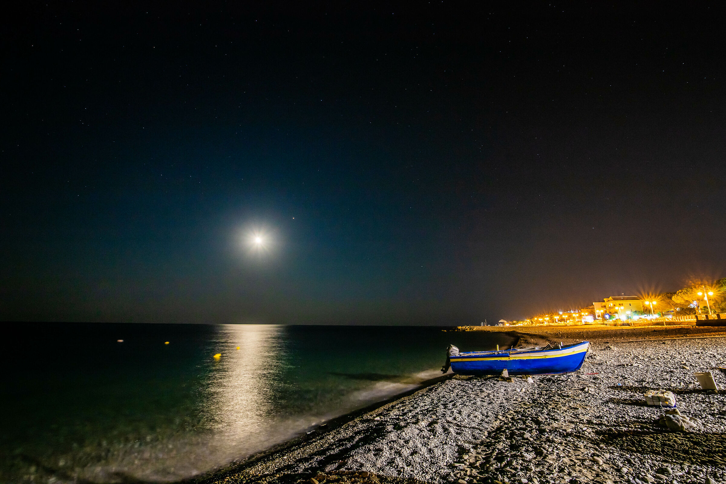 Ciottoli, mare cristallino e luci notturne